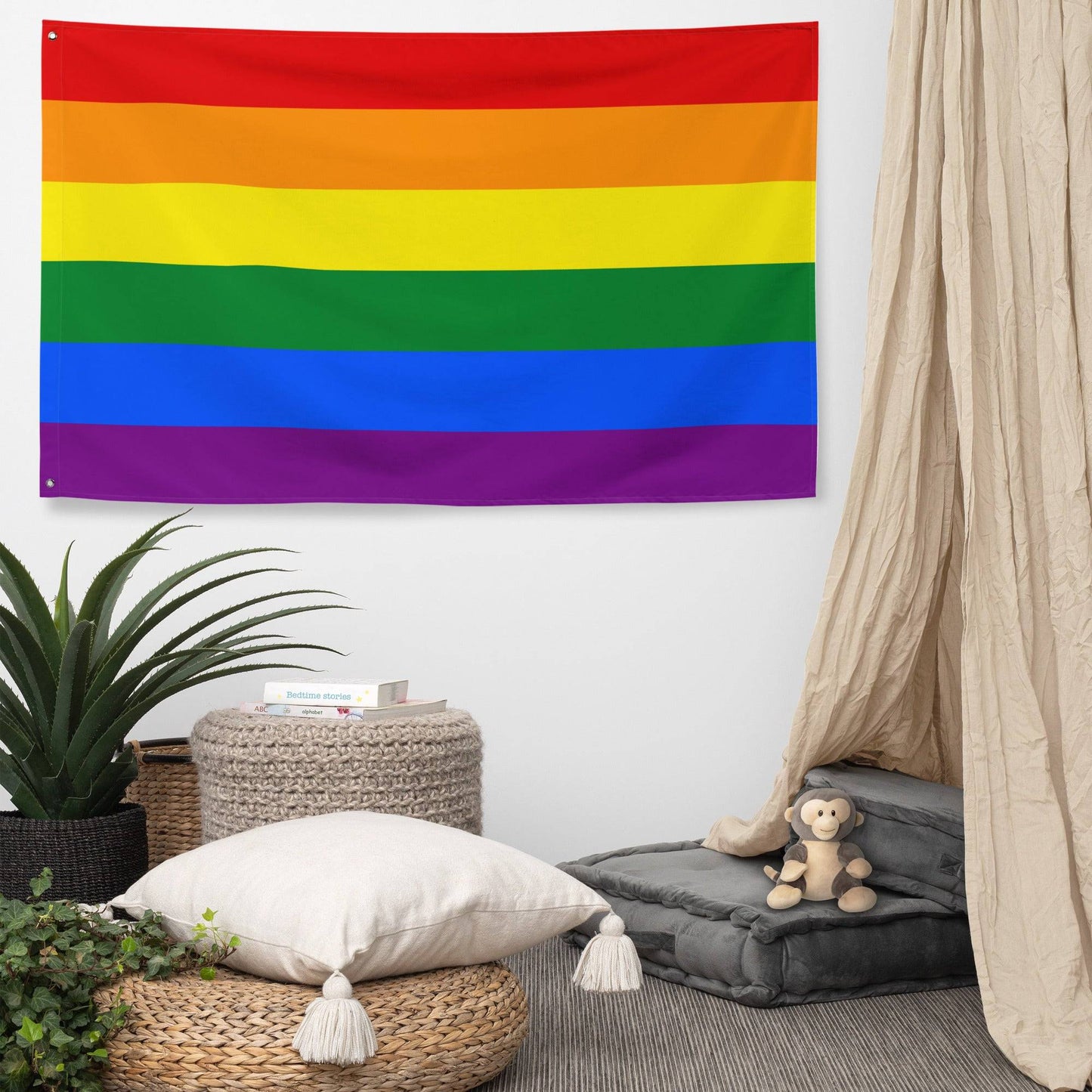 A Traditional Pride Flag from Pridelity, featuring six horizontal stripes in red, orange, yellow, green, blue, and purple, adorns the white brick wall of a charming rainbow shop.