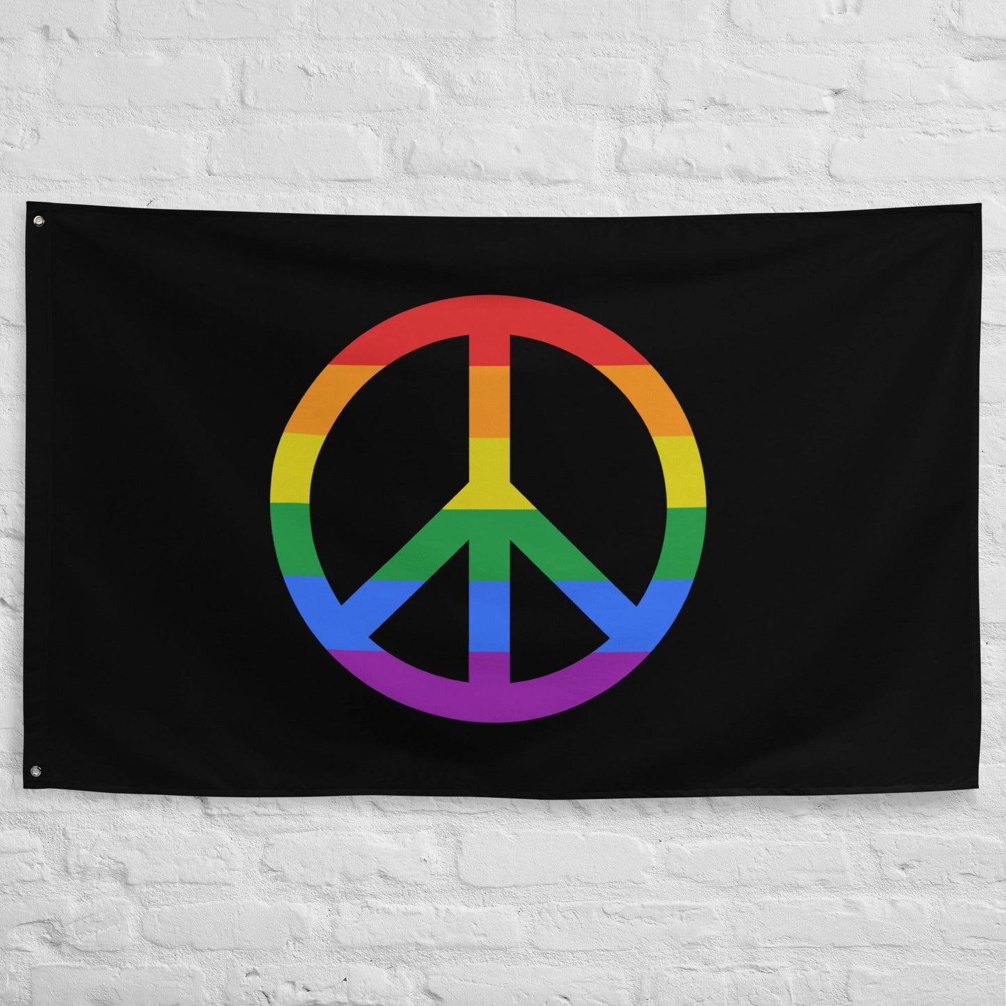 A "Peace Flag" by Pridelity, showcasing a vibrant peace symbol on a black background, hangs against a white brick wall.
