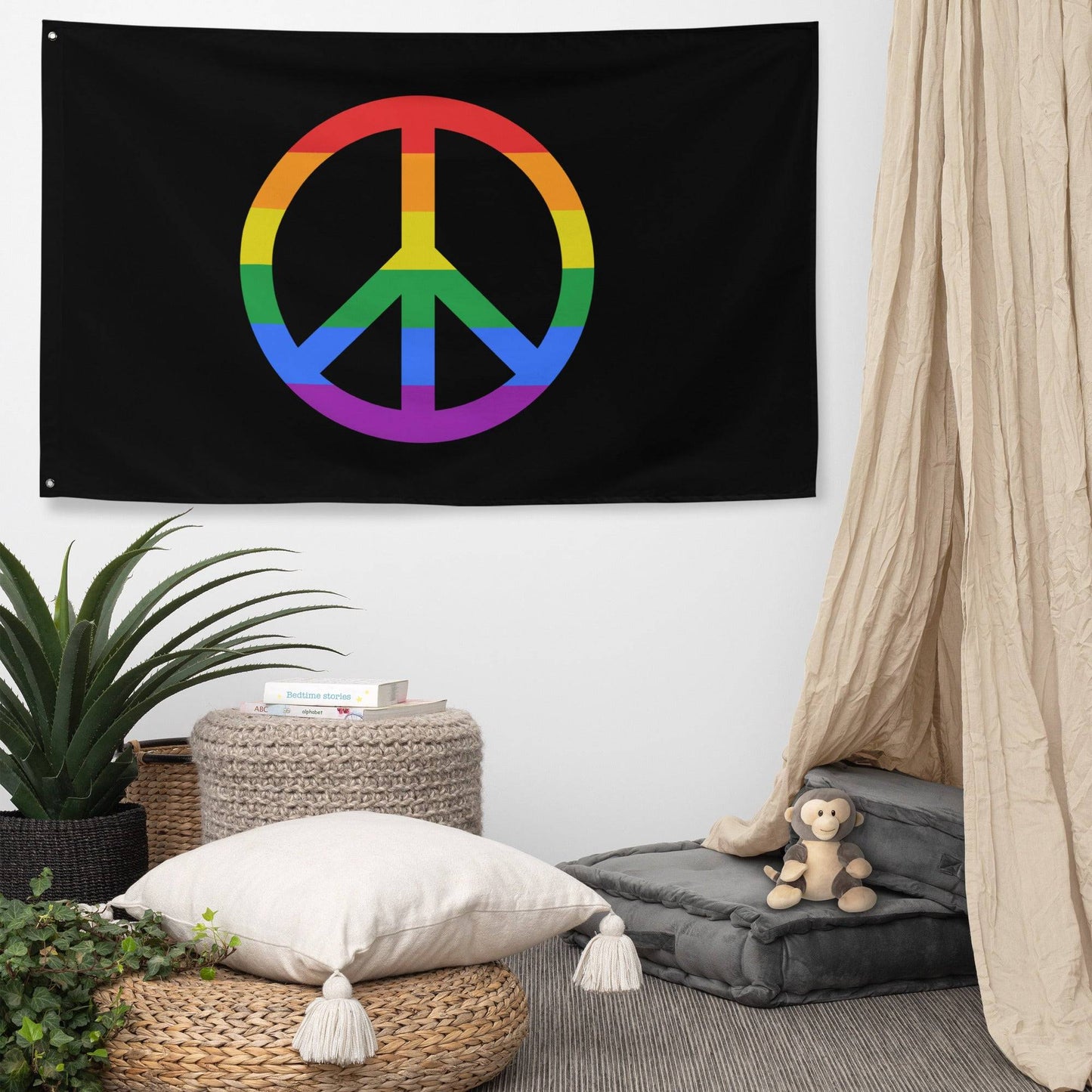 A "Peace Flag" by Pridelity, showcasing a vibrant peace symbol on a black background, hangs against a white brick wall.