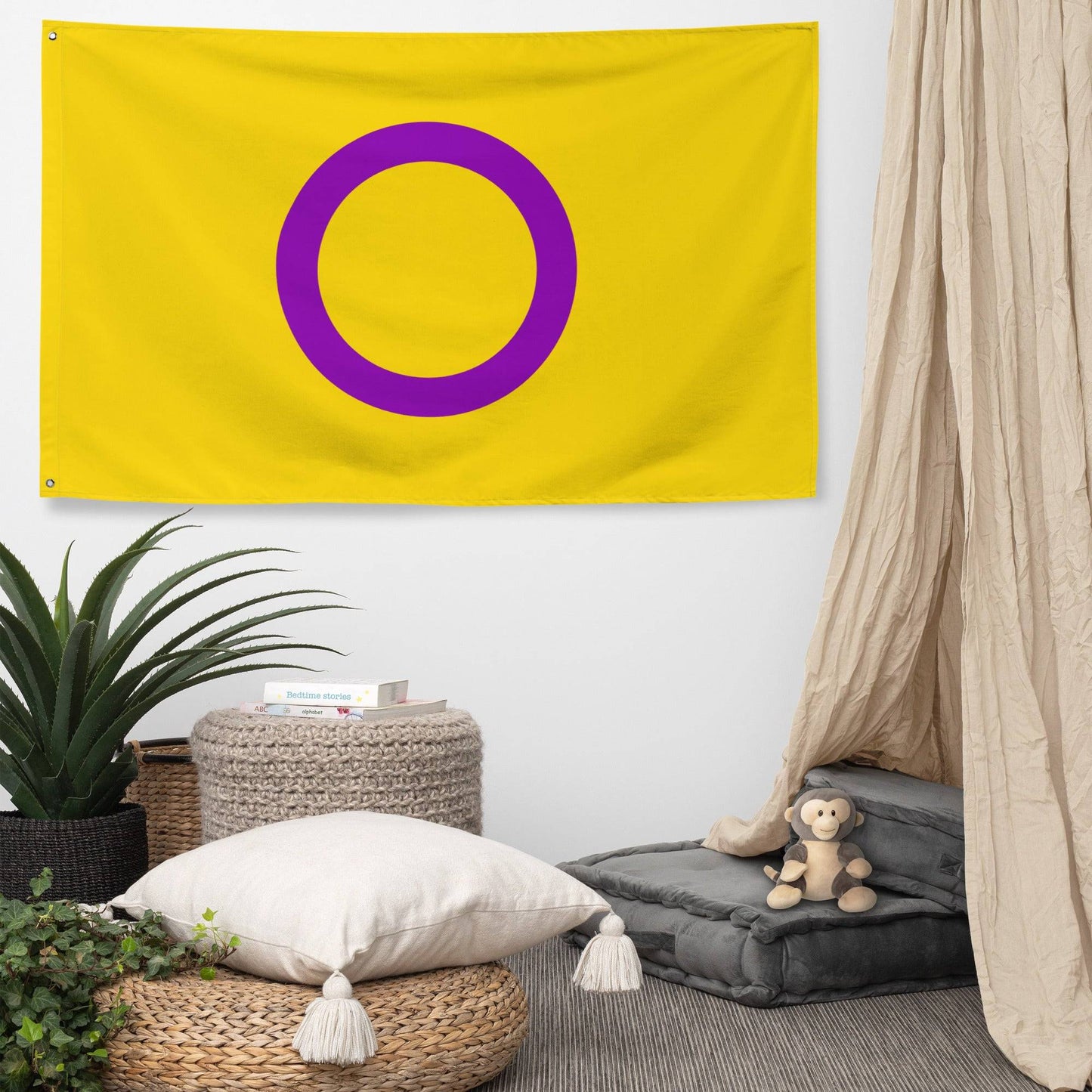 The Intersex Pride Flag by Pridelity, featuring a yellow design with a prominent purple circle at its center, displayed against a white brick wall, brings an energetic burst of color that evokes the joyful atmosphere of a rainbow-themed store.