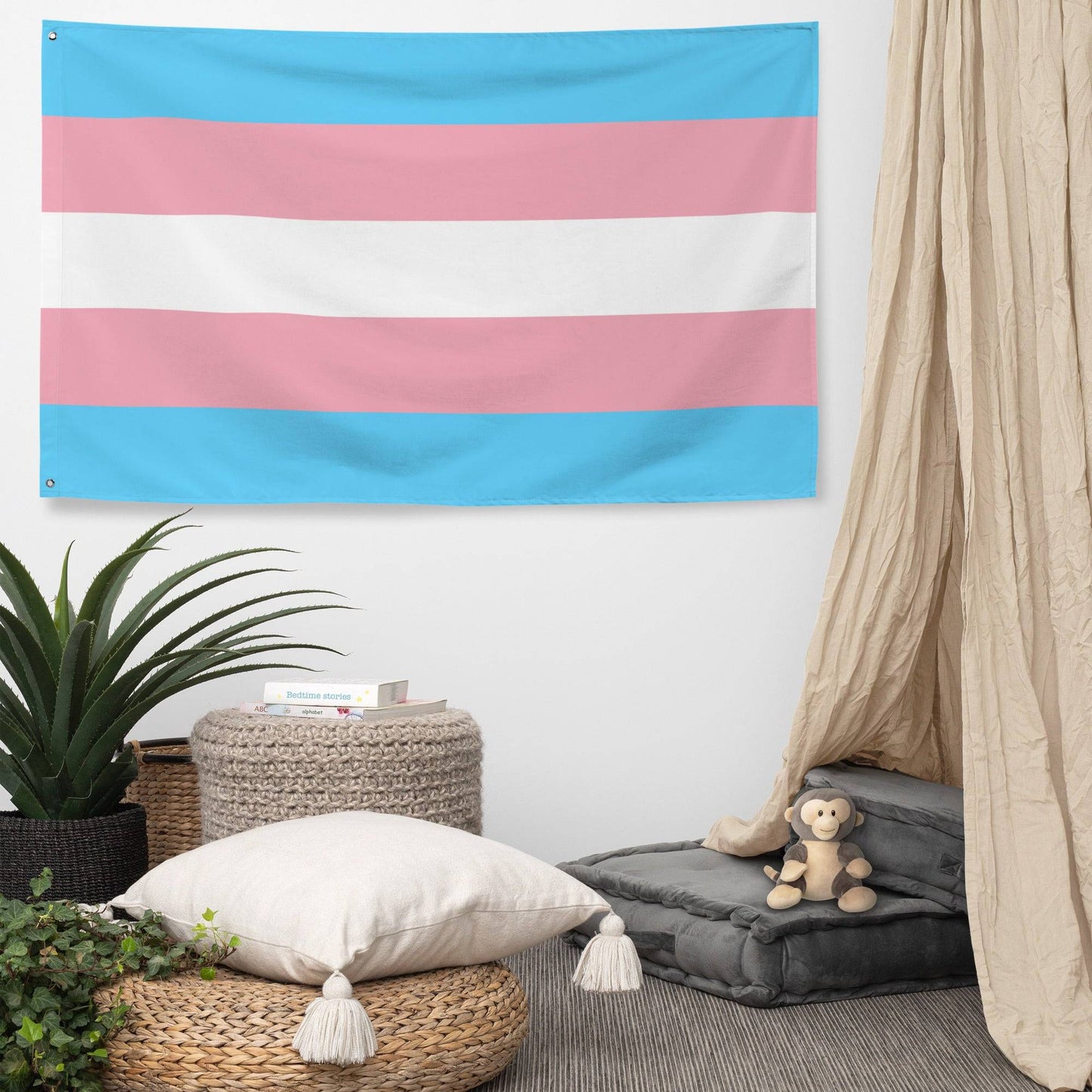 A Transgender Pride Flag from Pridelity adds an elegant touch to the white brick wall, with its design showcasing five horizontal stripes of light blue, pink, white, pink, and light blue.