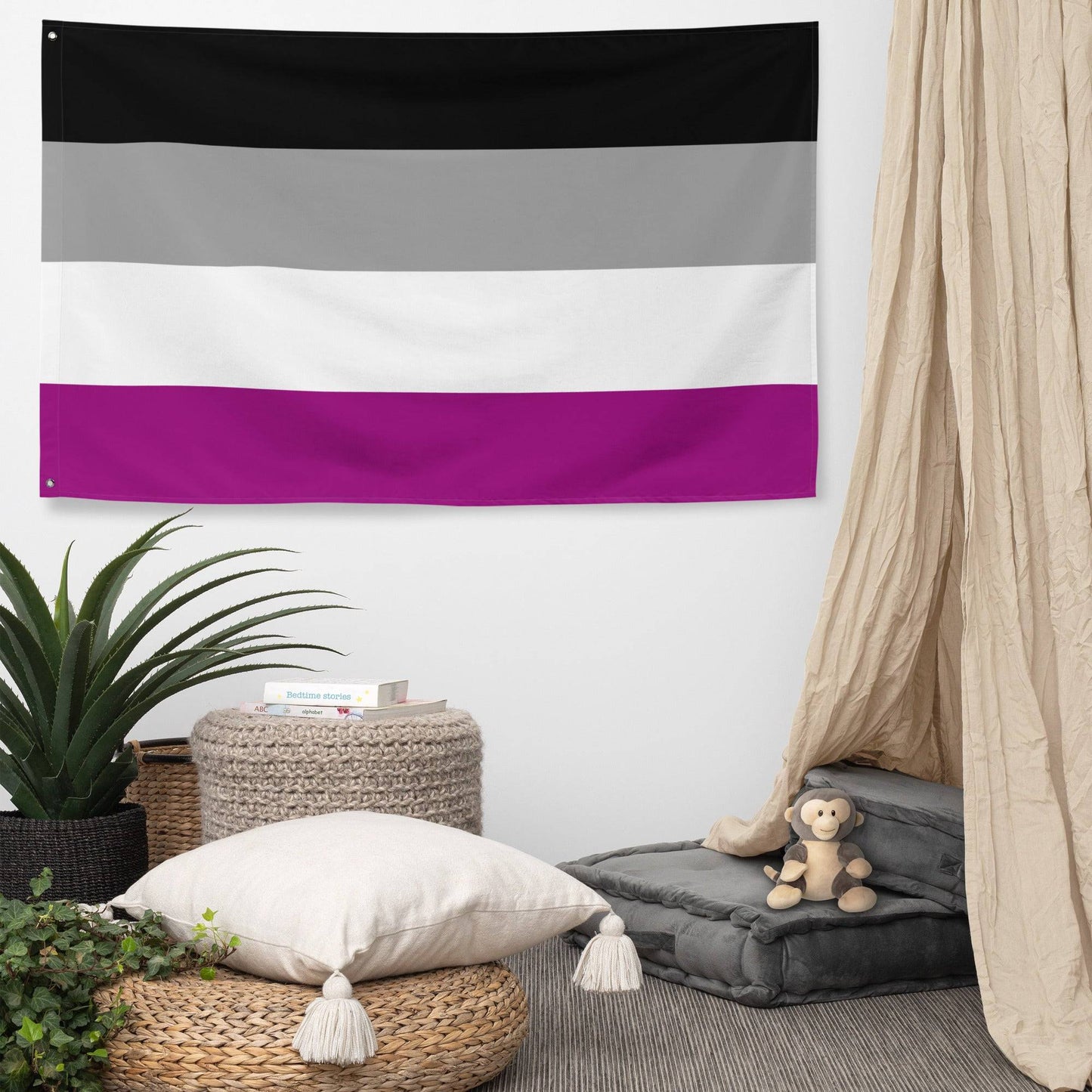 The image showcases the Asexual Pride Flag by Pridelity, part of the Pride Collections, hanging against a white brick wall. The flag features four horizontal stripes in black, gray, white, and purple.
