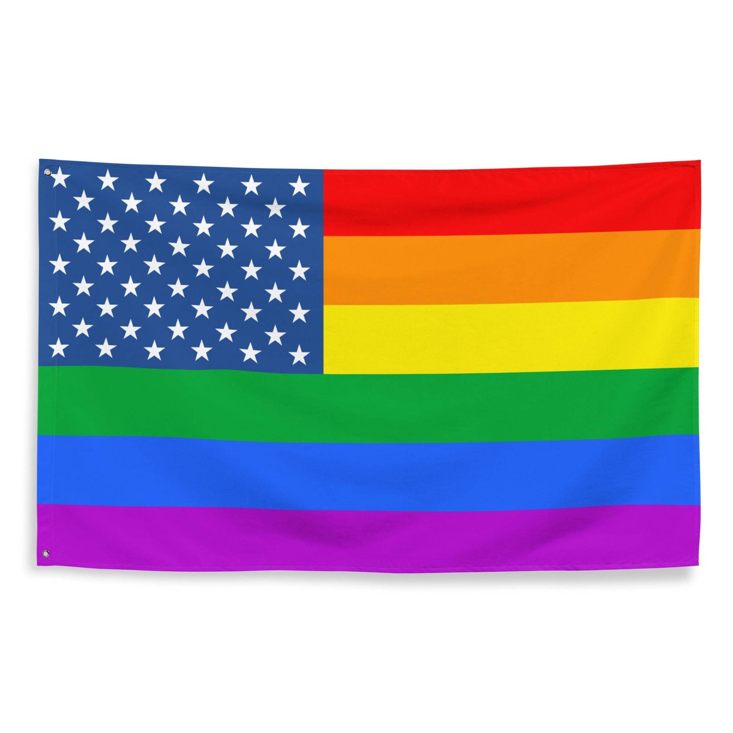The Pride Stars and Stripes Flag from Pridelity, featuring an American flag seamlessly merged with the vibrant rainbow stripes of the LGBTQ+ pride flag, hangs against a white brick wall. Its stars on a blue background in the top left beautifully contrast with the horizontal rainbow stripes, creating an inviting and colorful display.