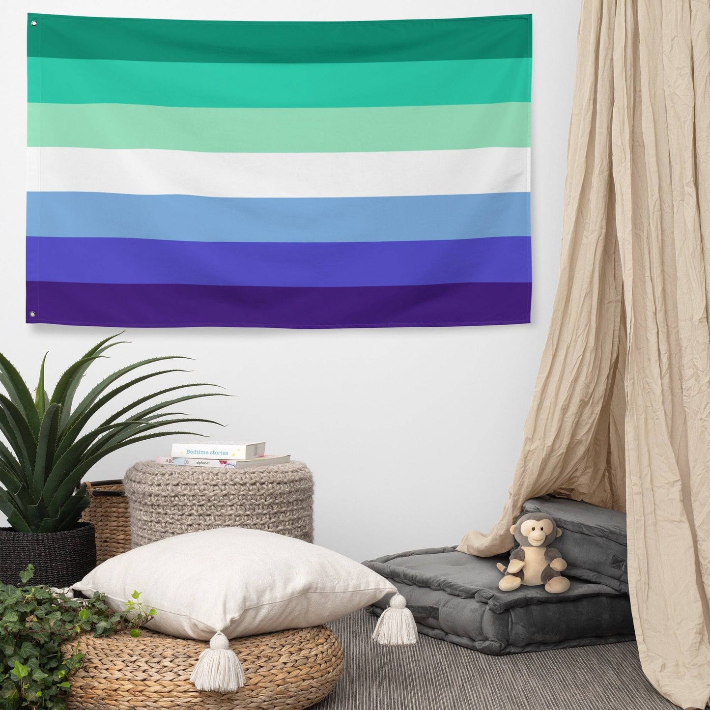 The Gay Men Pride Flag by Pridelity features horizontal stripes in a spectrum of colors reminiscent of a vibrant rainbow shop display. The flag showcases green, aqua, white, light blue, blue, and dark blue stripes descending against a white brick wall background.