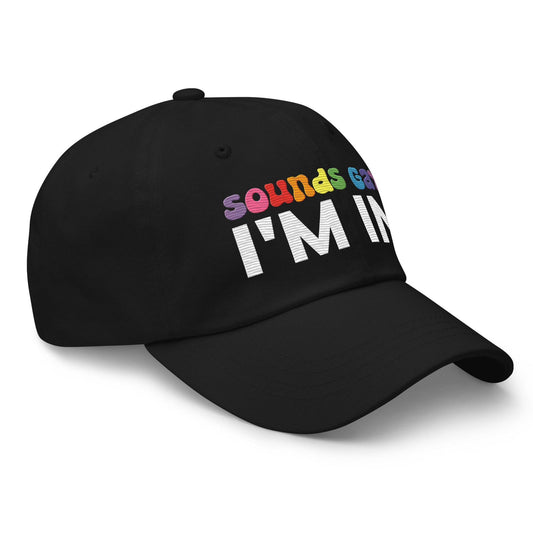 Introducing the "Sounds Gay I'm In Cap" by Pridelity, a black baseball cap ideal for pride outfits. It showcases the vibrant phrase "Sounds Gay" in contrast to the striking white "I'm In," making it a standout accessory for any celebration.