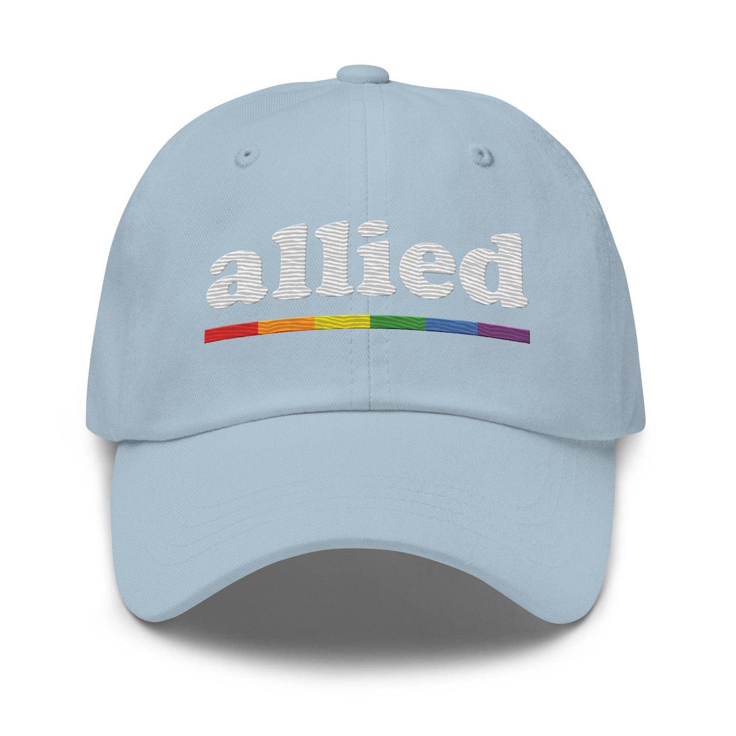 A Pridelity Allied Cap featuring "allied" embroidered in white above a vibrant, Pride-inspired rainbow line.