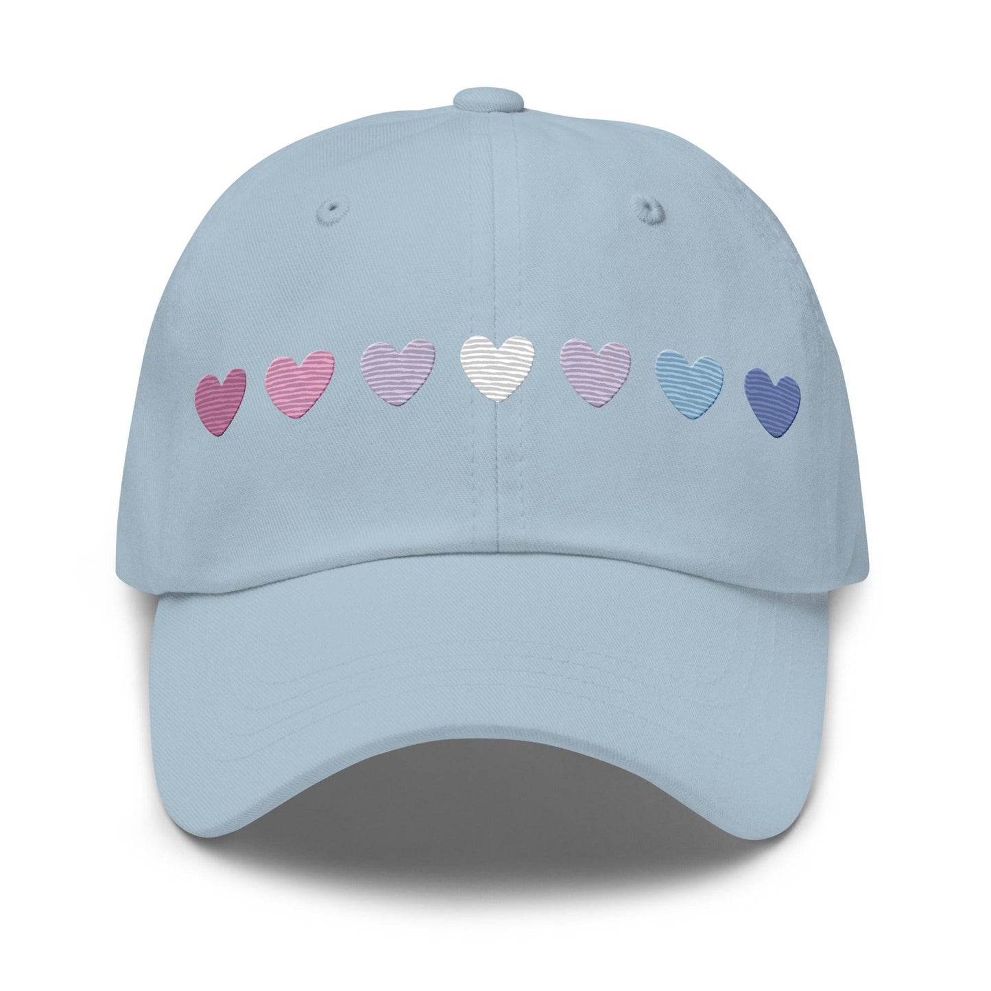 The Pridelity Bigender Hearts Cap, part of our Pride Collection, showcases a row of seven gradient heart symbols transitioning in color from pink to white to blue on a black base.