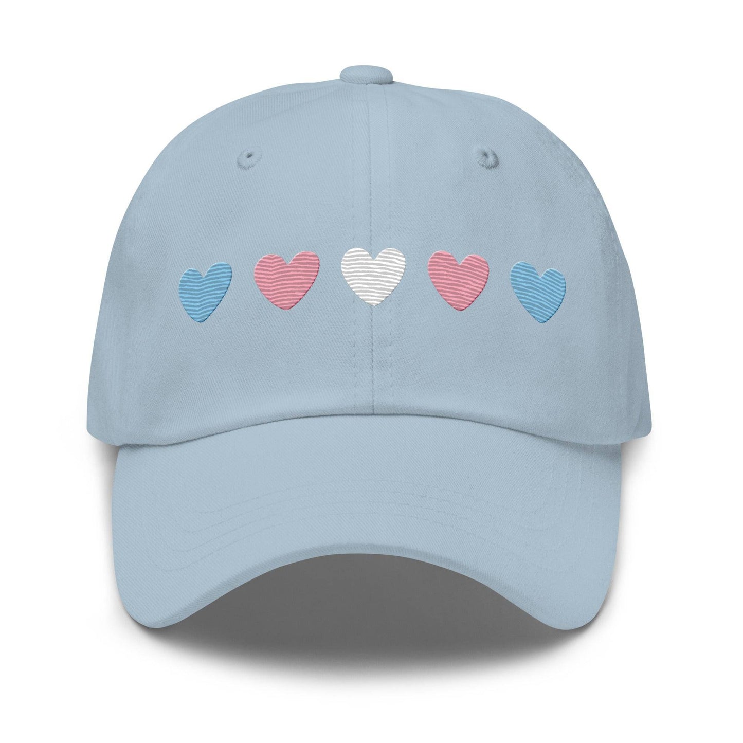 Introducing the "Trans Hearts Cap" from Pridelity, a black baseball cap adorned with embroidered pastel heart designs in pink, white, and blue on the front, making it an ideal accessory to enhance your pride outfits.