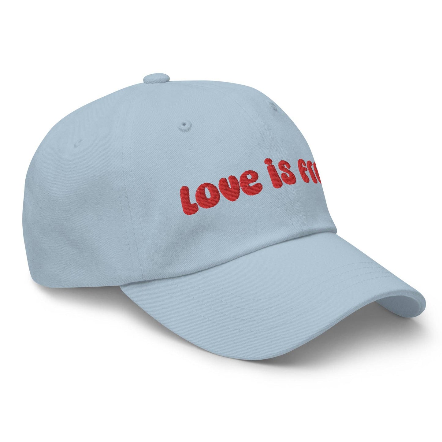 The Pridelity Love Is Free Cap, in a striking white color, is an ideal addition to pride outfits. It boasts the phrase "love is free" beautifully embroidered in bold red lettering on the front.