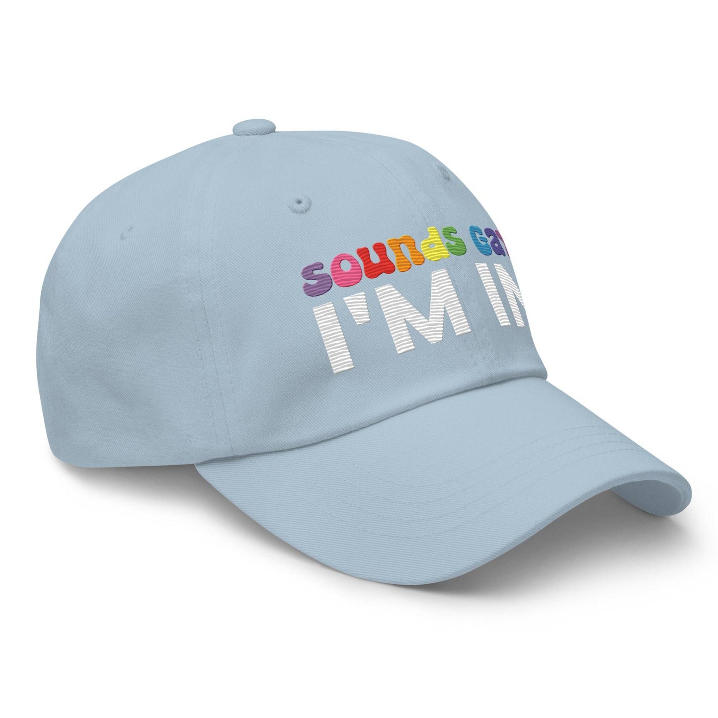 Introducing the "Sounds Gay I'm In Cap" by Pridelity, a black baseball cap ideal for pride outfits. It showcases the vibrant phrase "Sounds Gay" in contrast to the striking white "I'm In," making it a standout accessory for any celebration.