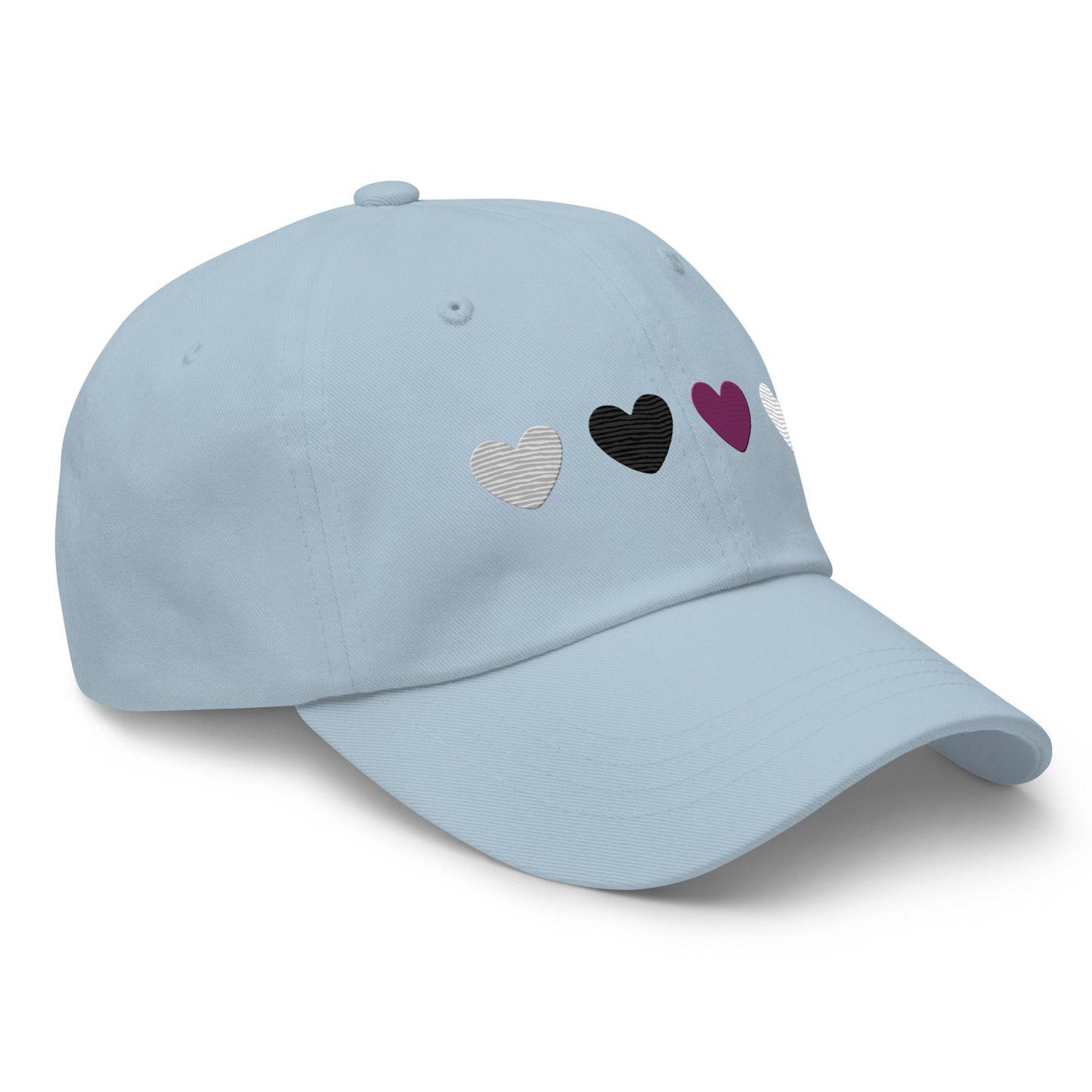 The Demisexual Hearts Cap from Pridelity, featuring four heart symbols in silver, black, purple, and white on a stone base, seamlessly complements pride outfits.