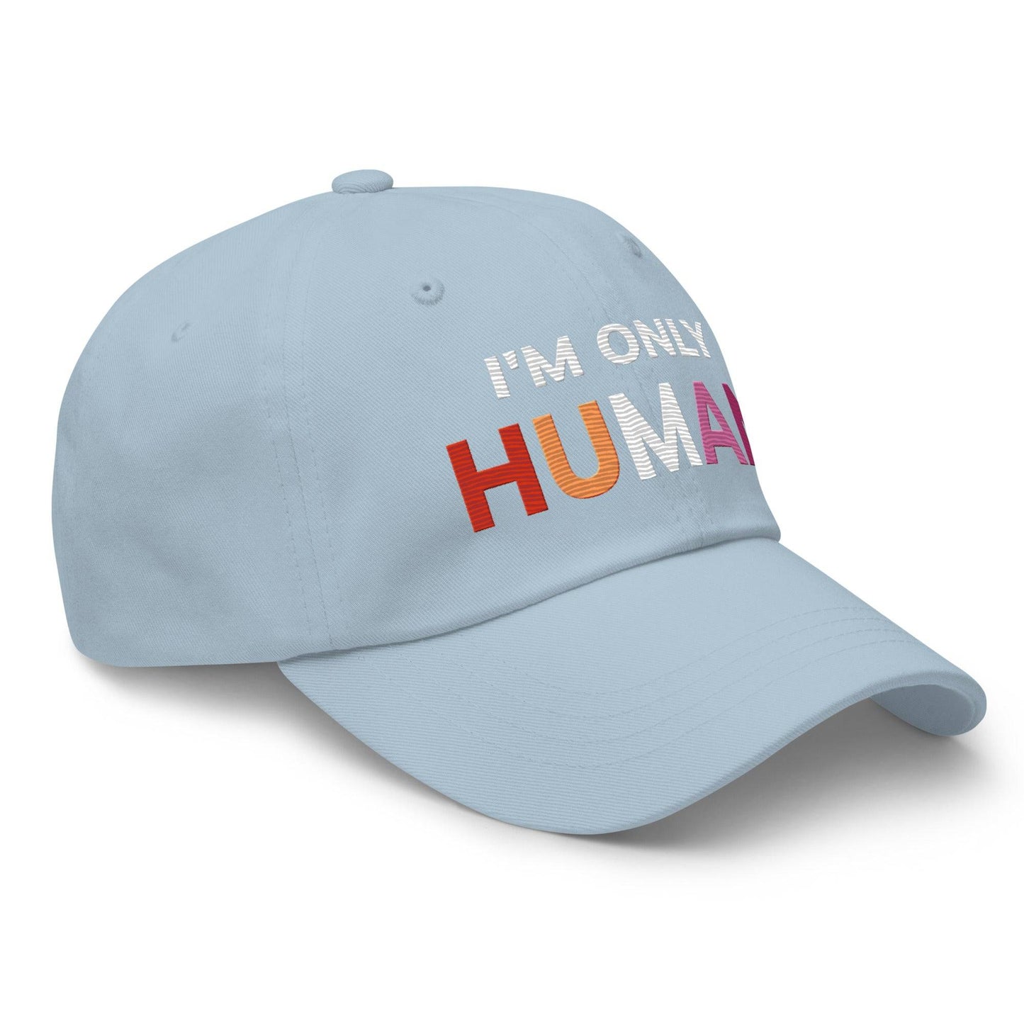The Pridelity "I'm Only Human Cap" is a black baseball cap ideal for pride outfits, prominently displaying the phrase "I'M ONLY HUMAN" on the front, with "HUMAN" in bold, colorful letters transitioning from orange to pink.