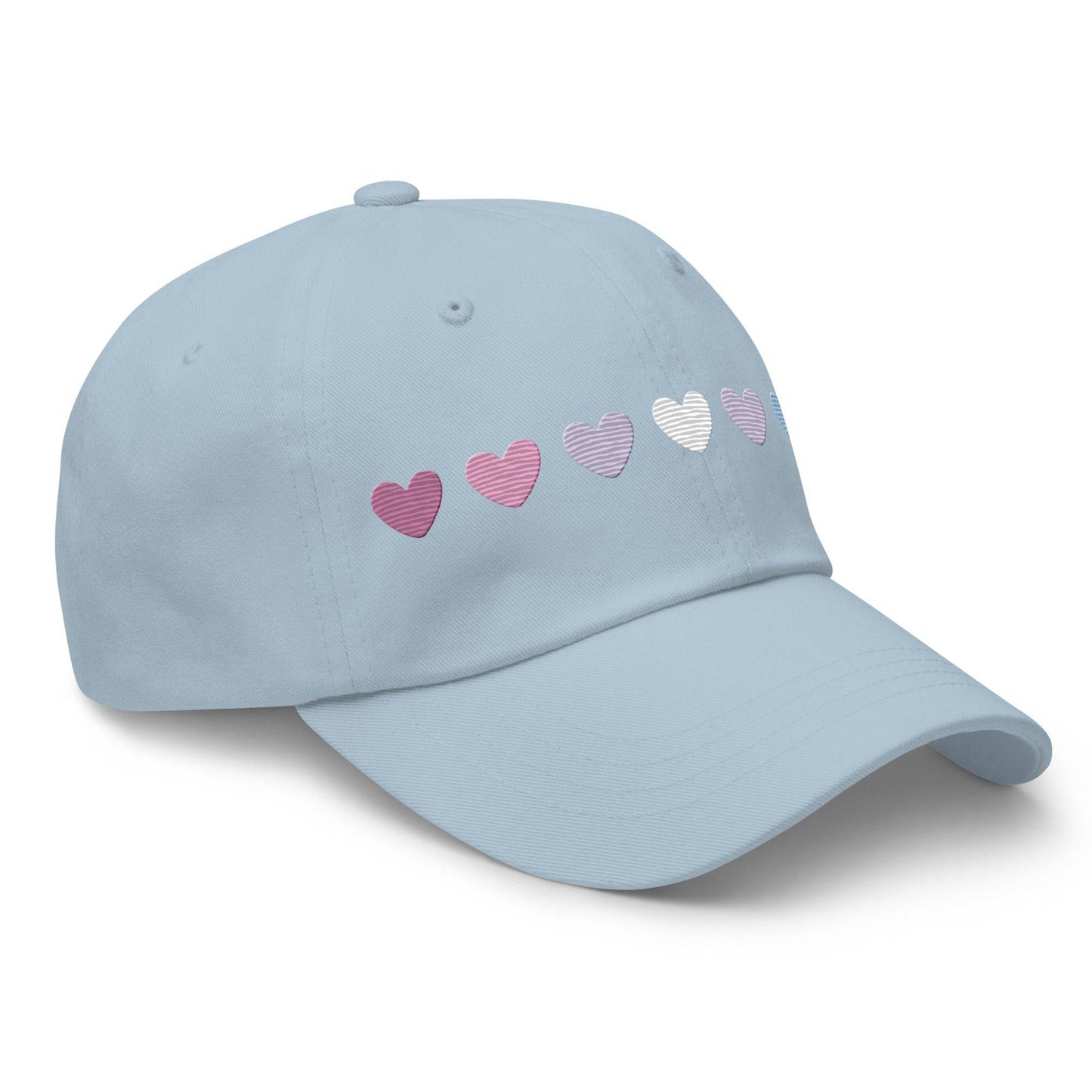 The Pridelity Bigender Hearts Cap, part of our Pride Collection, showcases a row of seven gradient heart symbols transitioning in color from pink to white to blue on a black base.