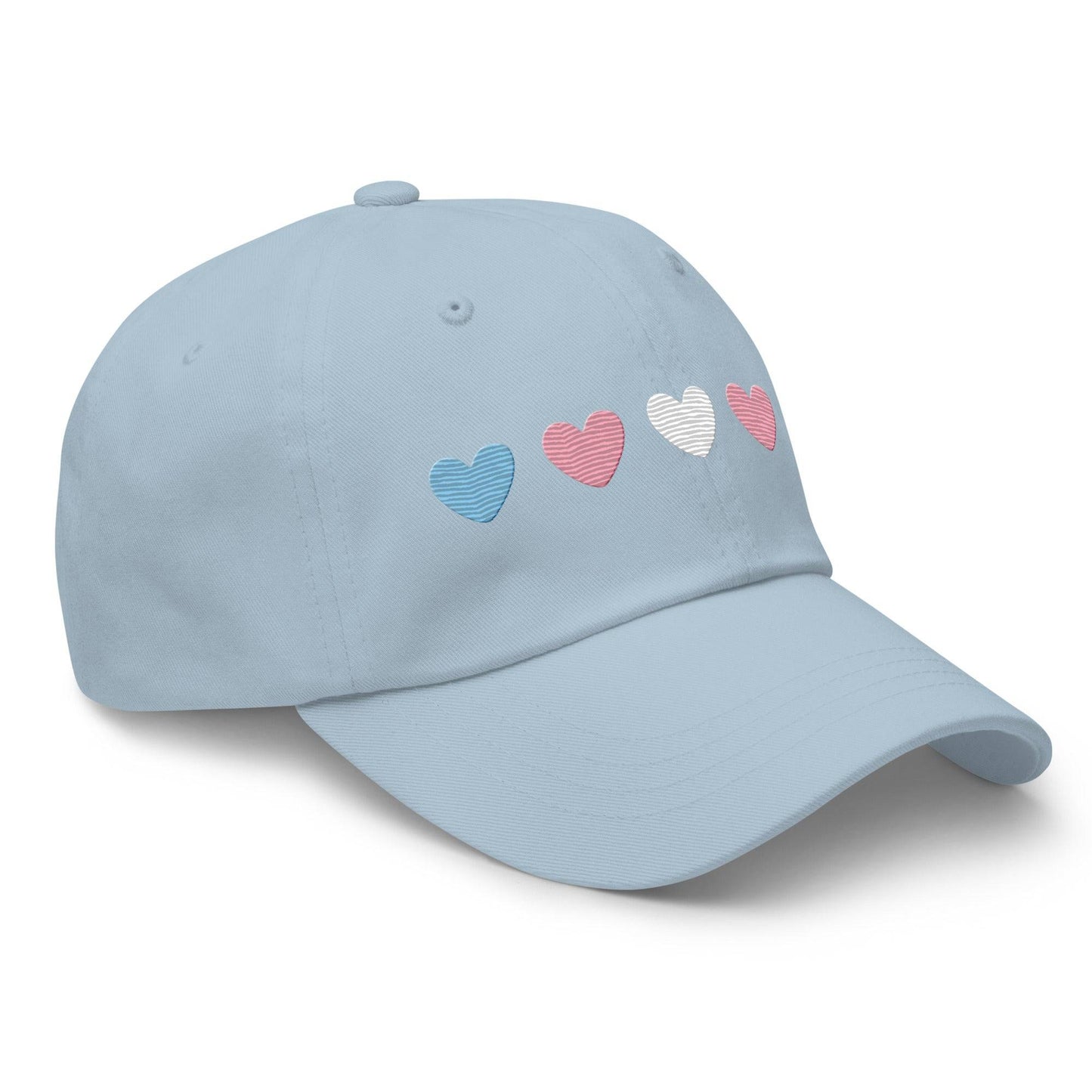 Introducing the "Trans Hearts Cap" from Pridelity, a black baseball cap adorned with embroidered pastel heart designs in pink, white, and blue on the front, making it an ideal accessory to enhance your pride outfits.