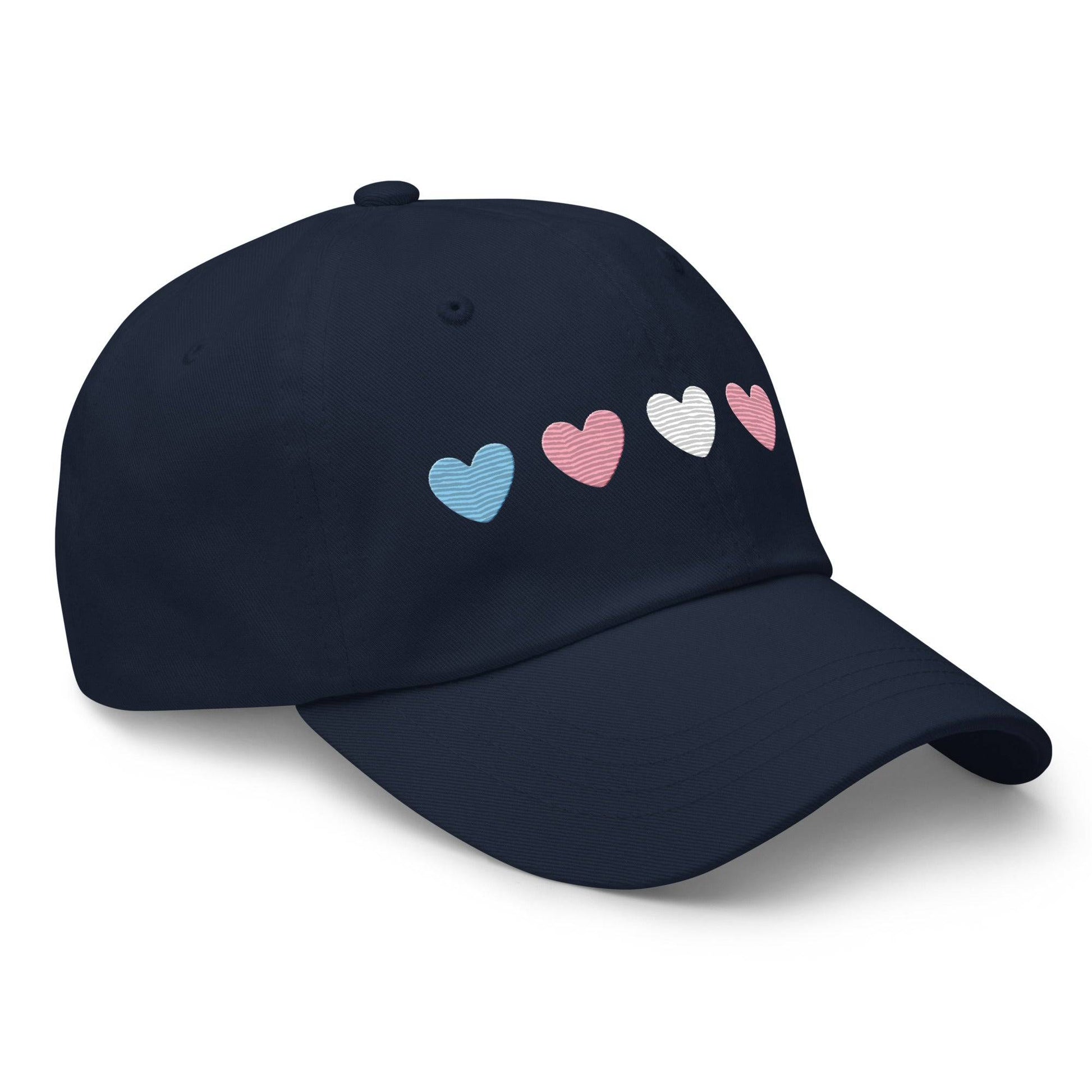 Introducing the "Trans Hearts Cap" from Pridelity, a black baseball cap adorned with embroidered pastel heart designs in pink, white, and blue on the front, making it an ideal accessory to enhance your pride outfits.