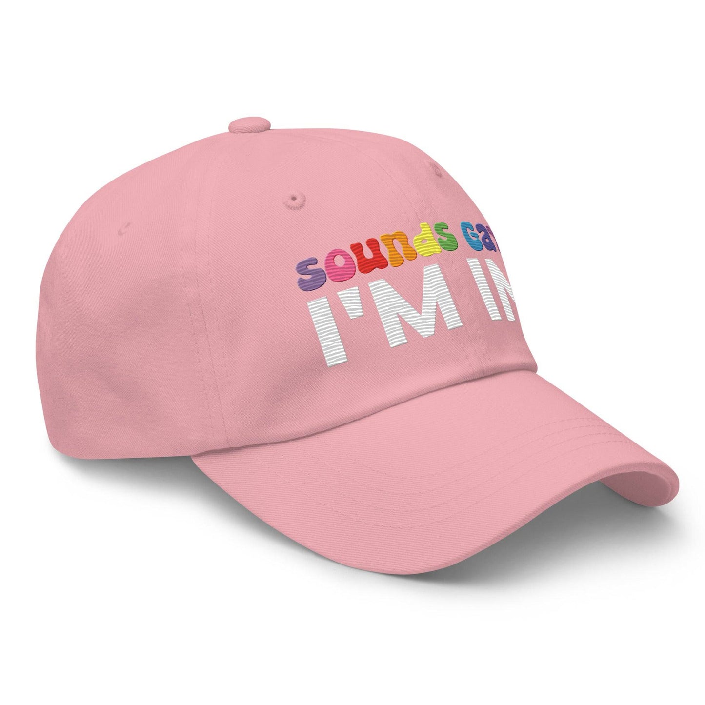 Introducing the "Sounds Gay I'm In Cap" by Pridelity, a black baseball cap ideal for pride outfits. It showcases the vibrant phrase "Sounds Gay" in contrast to the striking white "I'm In," making it a standout accessory for any celebration.