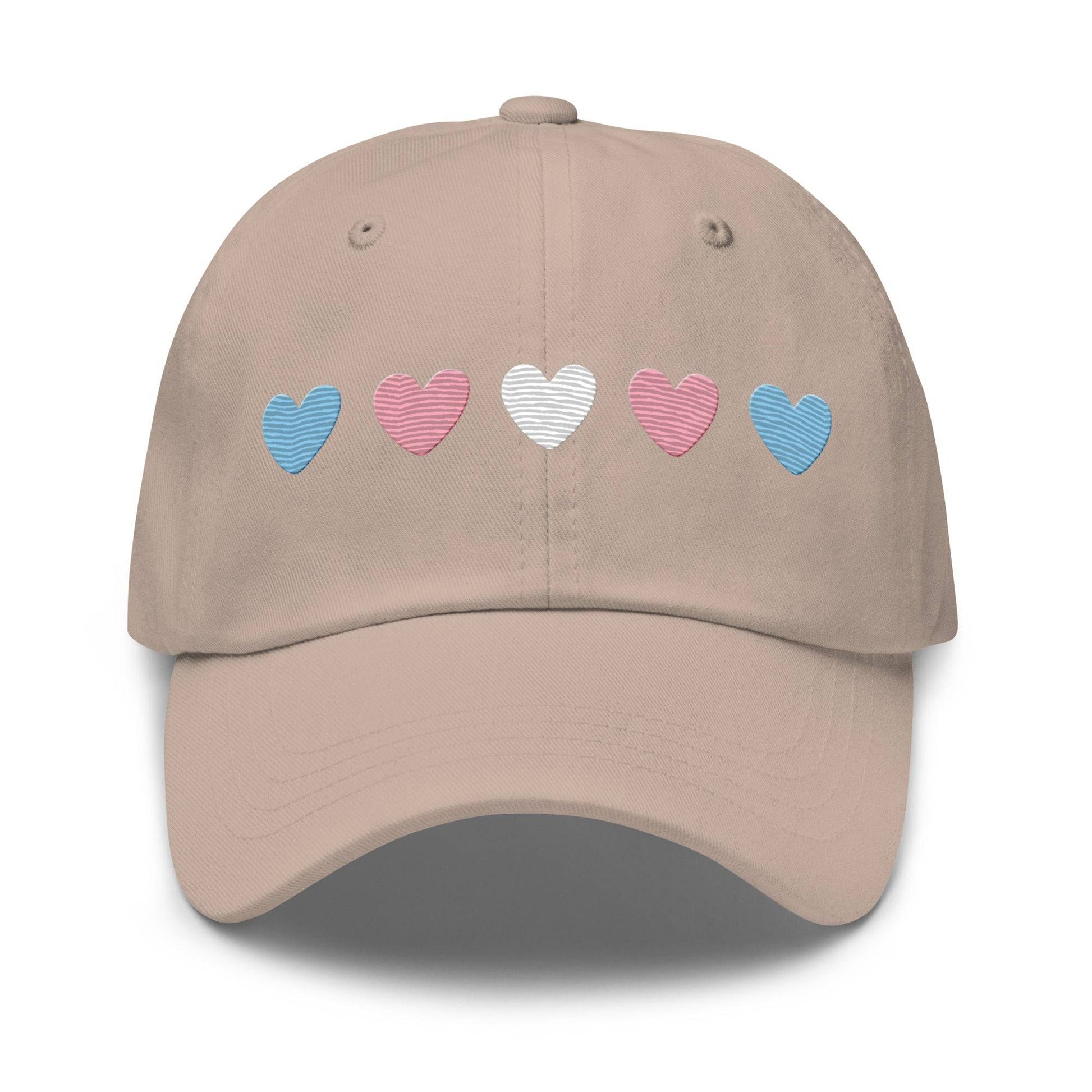 Introducing the "Trans Hearts Cap" from Pridelity, a black baseball cap adorned with embroidered pastel heart designs in pink, white, and blue on the front, making it an ideal accessory to enhance your pride outfits.