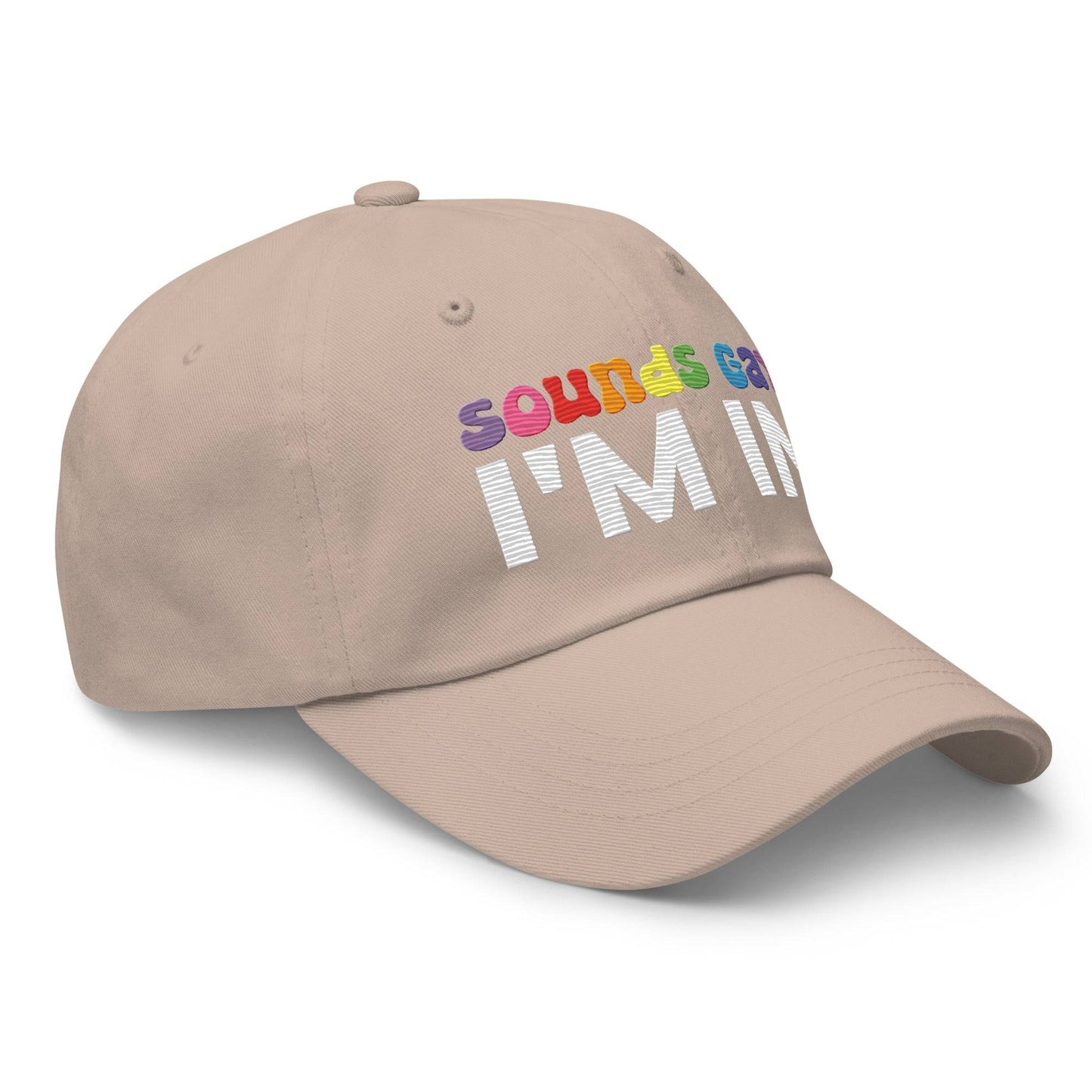 Introducing the "Sounds Gay I'm In Cap" by Pridelity, a black baseball cap ideal for pride outfits. It showcases the vibrant phrase "Sounds Gay" in contrast to the striking white "I'm In," making it a standout accessory for any celebration.