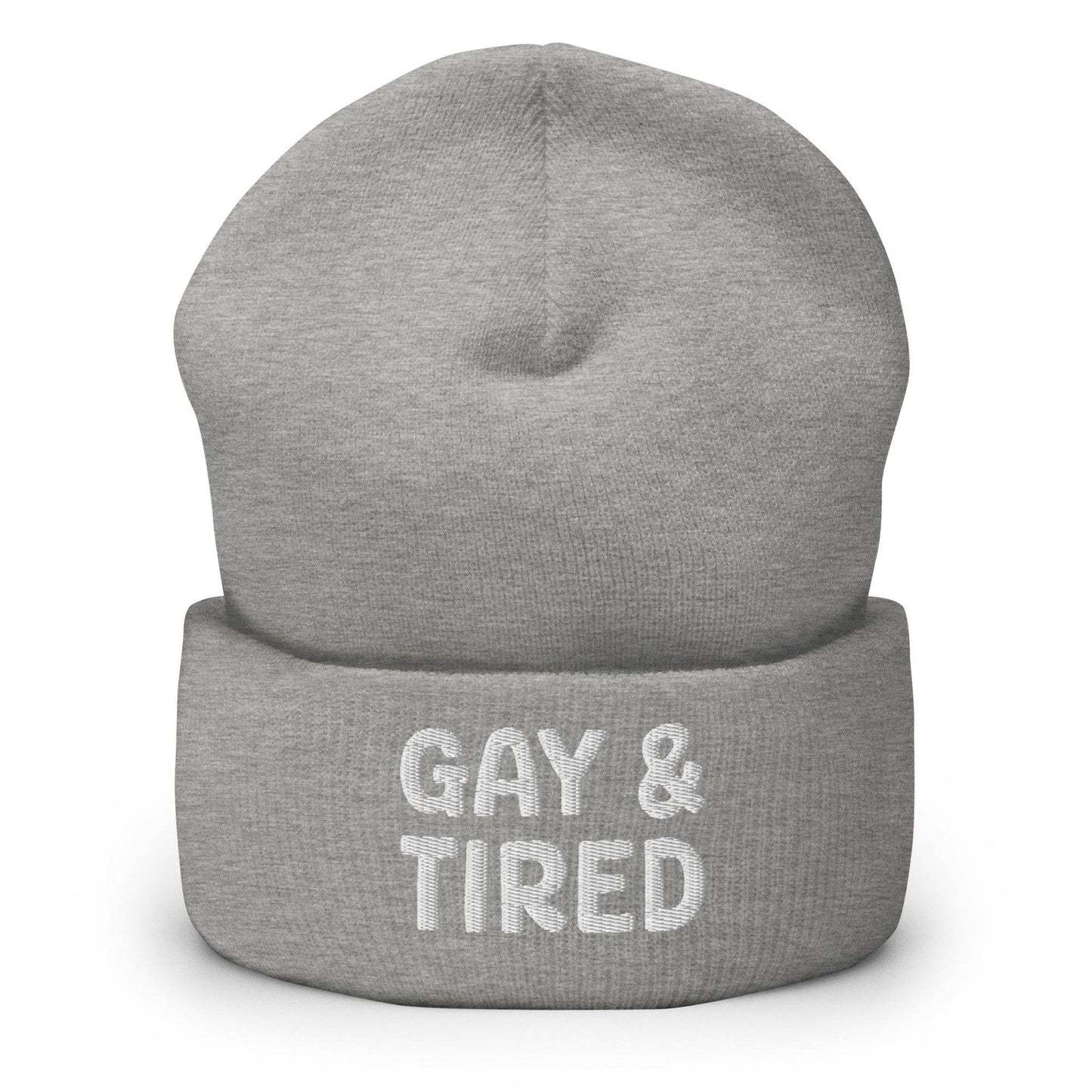 The Gay & Tired Beanie by Pridelity is a stylish accessory for showcasing your individuality, featuring white embroidered text on a black background that boldly states "GAY & TIRED" across the front. Its folded bottom ensures the message is prominently displayed.