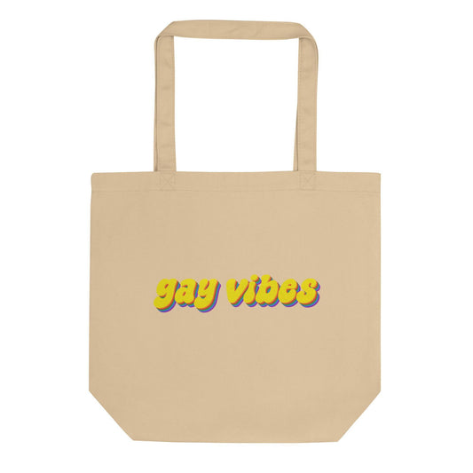 Introducing the Gay Vibes Tote Bag from Pridelity, a stylish black tote that proudly displays "gay vibes" in striking, colorful lettering. The dynamic text features a stunning gradient transition from yellow to purple, enhanced with a shadow effect. Ideal for any event, this versatile bag is designed with two durable top handles.