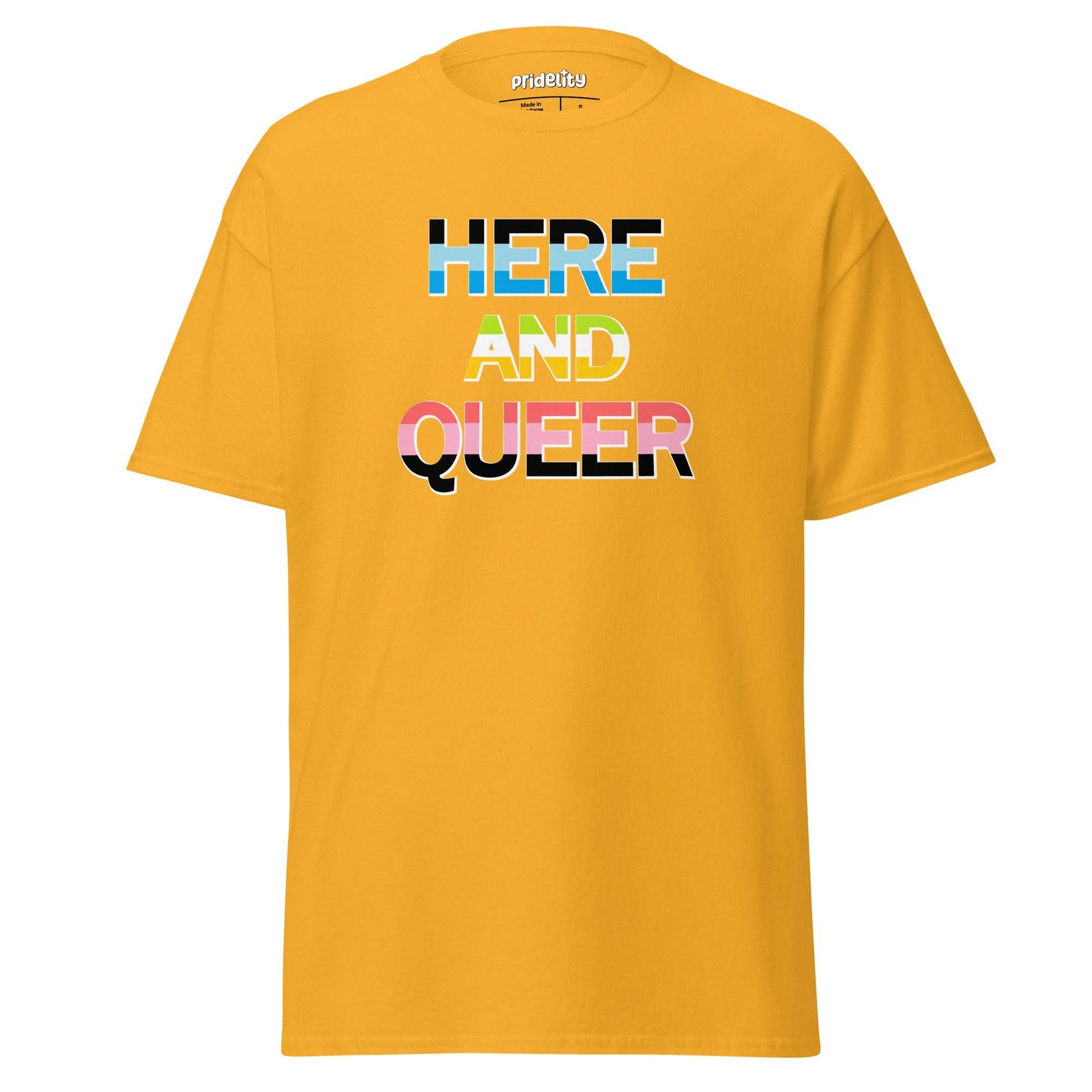 The Pridelity "Here And Queer" T-shirt showcases bold, block letters filled with the vibrant light blue, pink, and white of the transgender pride flag against a classic black background. Make a statement with this eye-catching item from our pride collection.