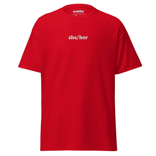 A black She/Her T-shirt by Pridelity showcases the words "she/her" in bold white text on the front, with the collar tag proudly reading "Prideify.