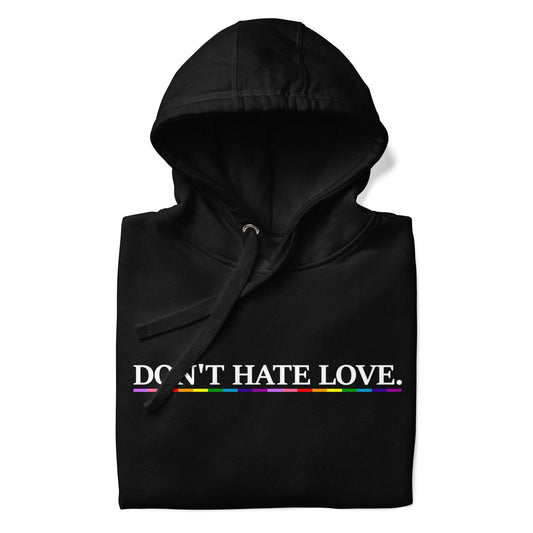 Pridelity's Don't Hate Love Hoodie features the phrase "DON'T HATE LOVE." in white text, highlighted by a striking rainbow stripe, printed boldly across the chest on a black background.