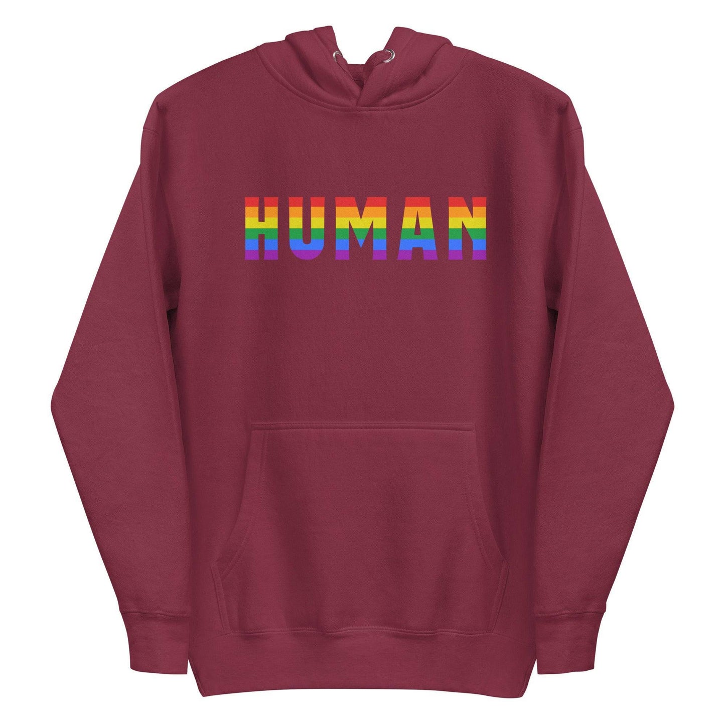 A folded Human Hoodie by Pridelity, featuring the word "HUMAN" prominently displayed in bold, rainbow-colored letters on the front. The black pride hoodie has its hood up, with untied drawstrings resting on the fabric.