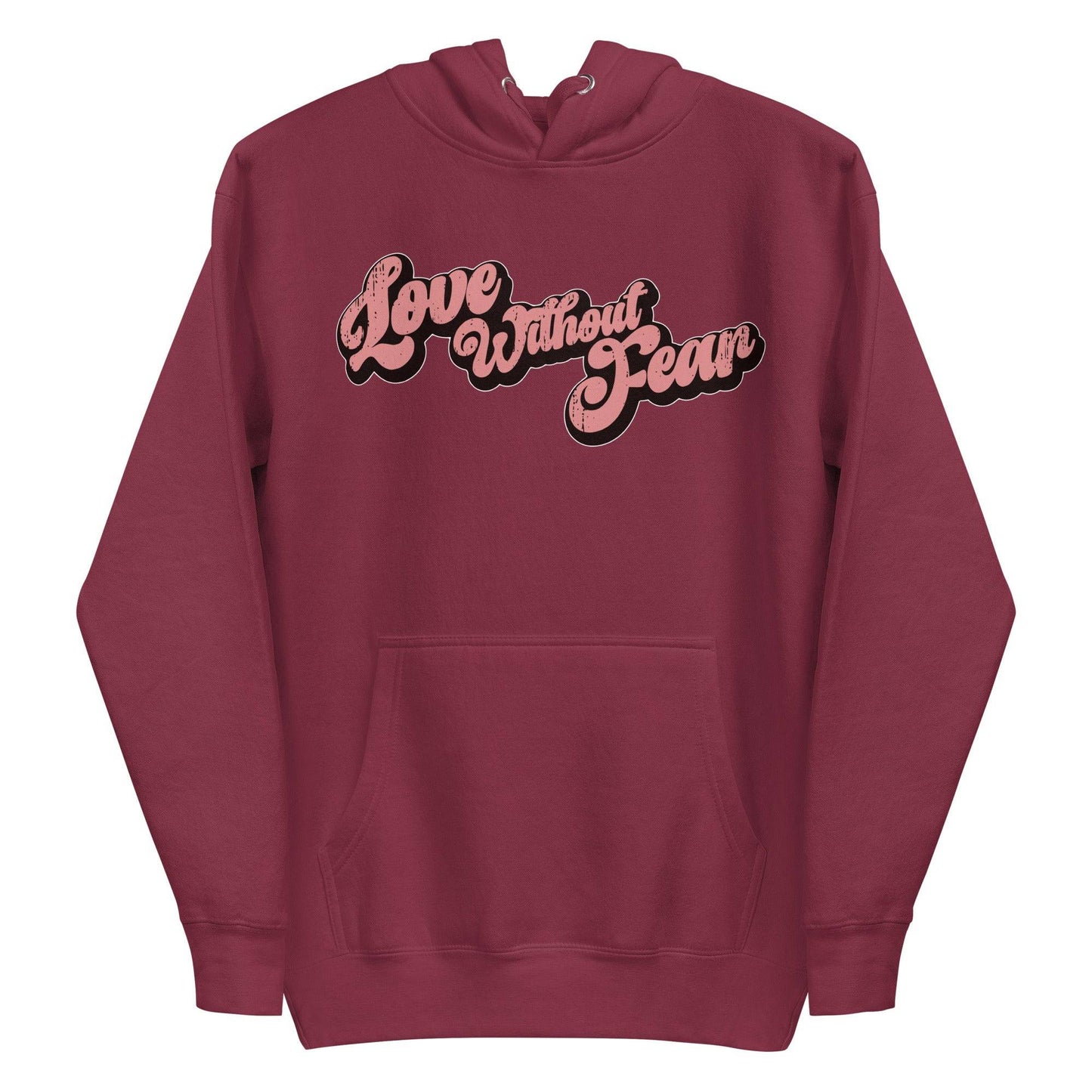 The Love Without Fear Hoodie by Pridelity comes in a dusty rose hue, featuring the phrase "Love Without Fear" across the front in a stylized, bold script reminiscent of classic pride shirts. The vintage text has contrasting black outlines and is centered on the chest. This hoodie also includes a front pocket and drawstrings.