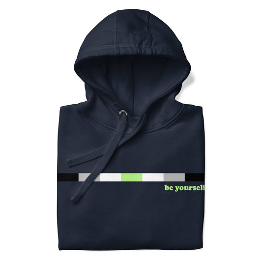 Introducing the Pridelity Agender Hoodie: a navy blue hoodie featuring a horizontal color bar in black, gray, white, and green. Adjacent to the bar on the right side is green text that reads "be yourself." This exclusive item from our Pride Collection includes a front pocket and drawstring hood.