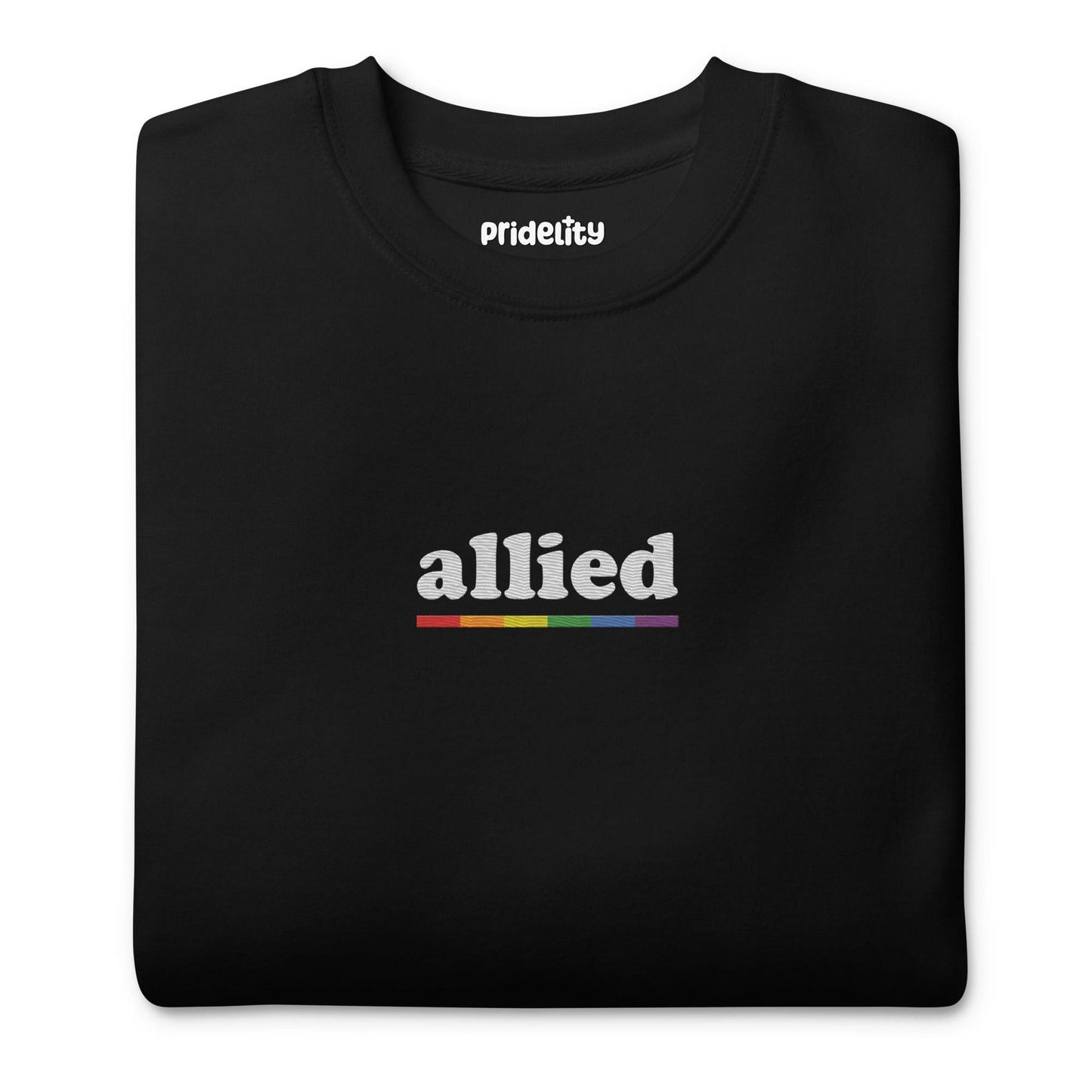 This Allied Sweatshirt by Pridelity, from our Pride Collection, showcases the word "allied" in lowercase letters. Beneath it is a multi-colored horizontal line in shades of gray, blue, yellow, black, and red to honor diversity. The look is finished with a classic crew neck for timeless style.