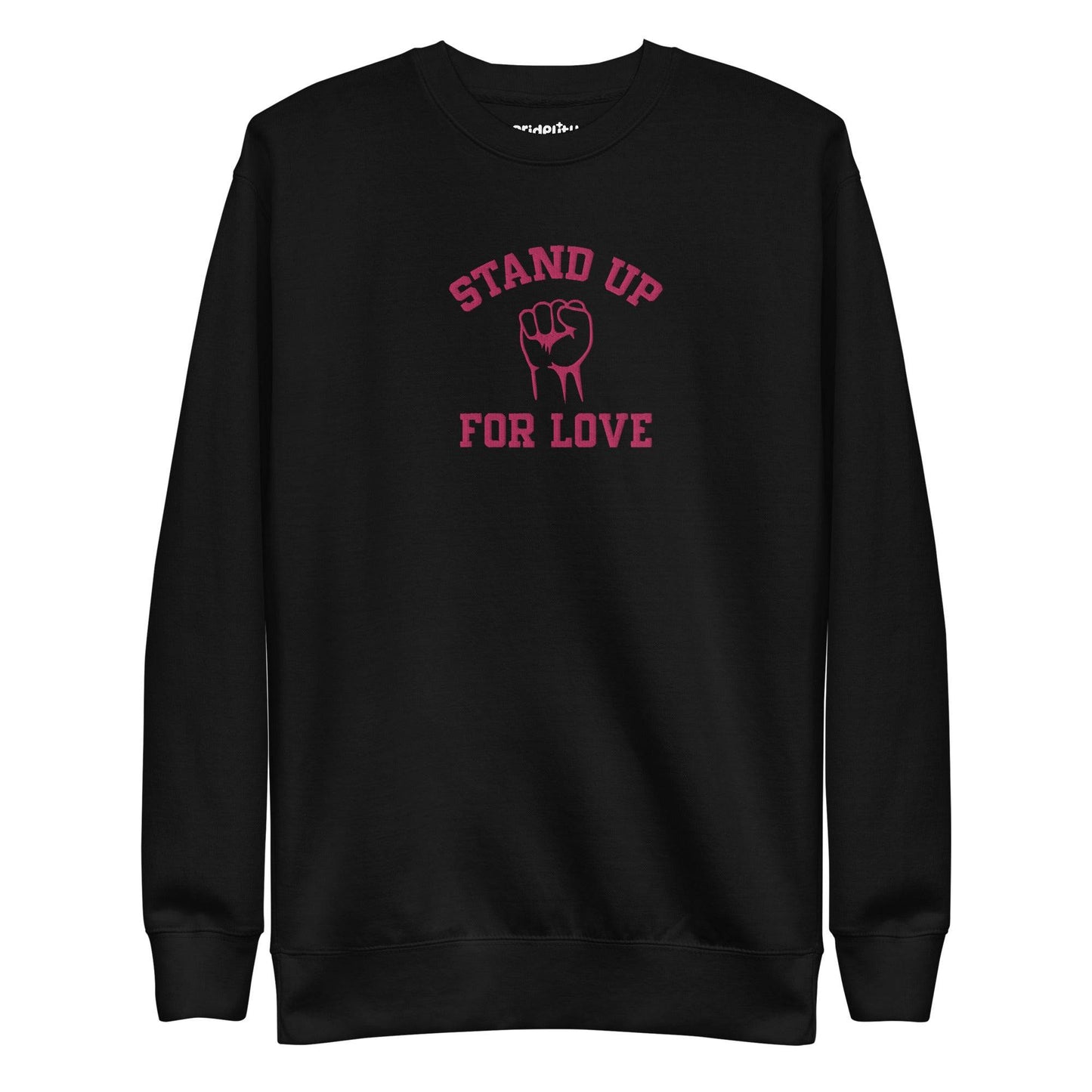 A folded white Pridelity Stand Up Sweatshirt showcases the phrase "STAND UP FOR LOVE" in red, encircling a striking graphic of a raised fist, making it a distinctive addition to any pride collection.