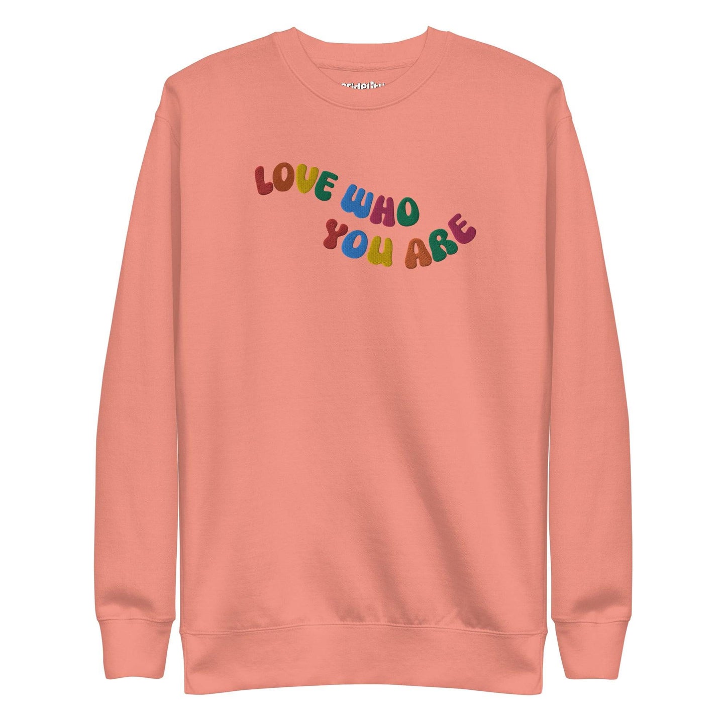 A black sweatshirt, neatly folded, prominently features the "LOVE WHO YOU ARE" message in bold, vibrant letters reminiscent of rainbow attire, with the brand name "Pridelity" elegantly displayed at the top.