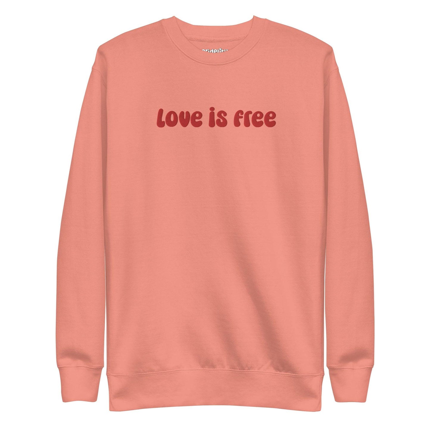 The Love Is Free Sweatshirt by Pridelity is a white sweatshirt with "love is free" boldly displayed in red letters across the chest, capturing the vibrant and inclusive essence of rainbow clothes.