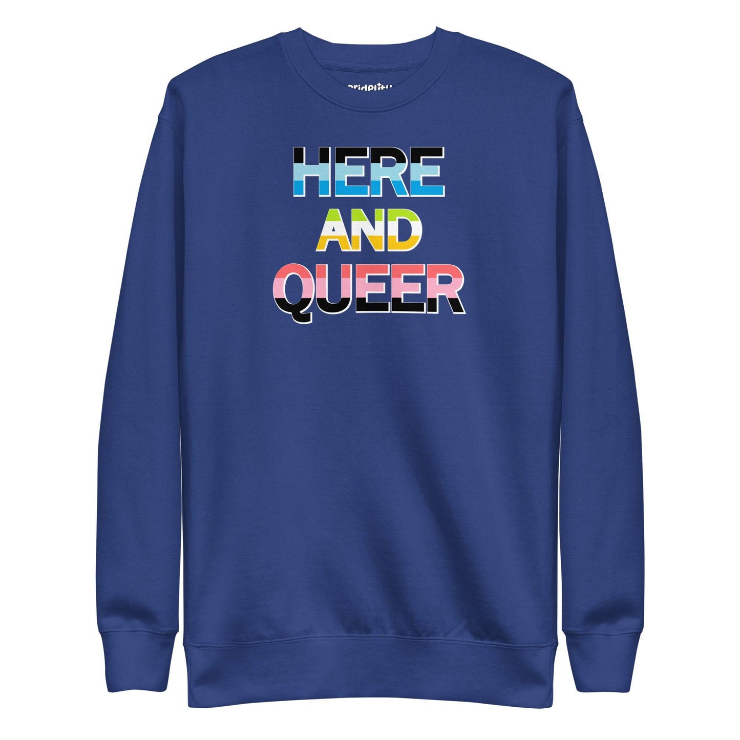 A "Here And Queer" sweatshirt by Pridelity, in a striking Team Royal shade, features a bold print and vibrant rainbow gradient design that elegantly represents LGBTQ+ pride.
