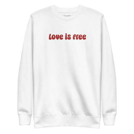 The Love Is Free Sweatshirt by Pridelity is a white sweatshirt with "love is free" boldly displayed in red letters across the chest, capturing the vibrant and inclusive essence of rainbow clothes.
