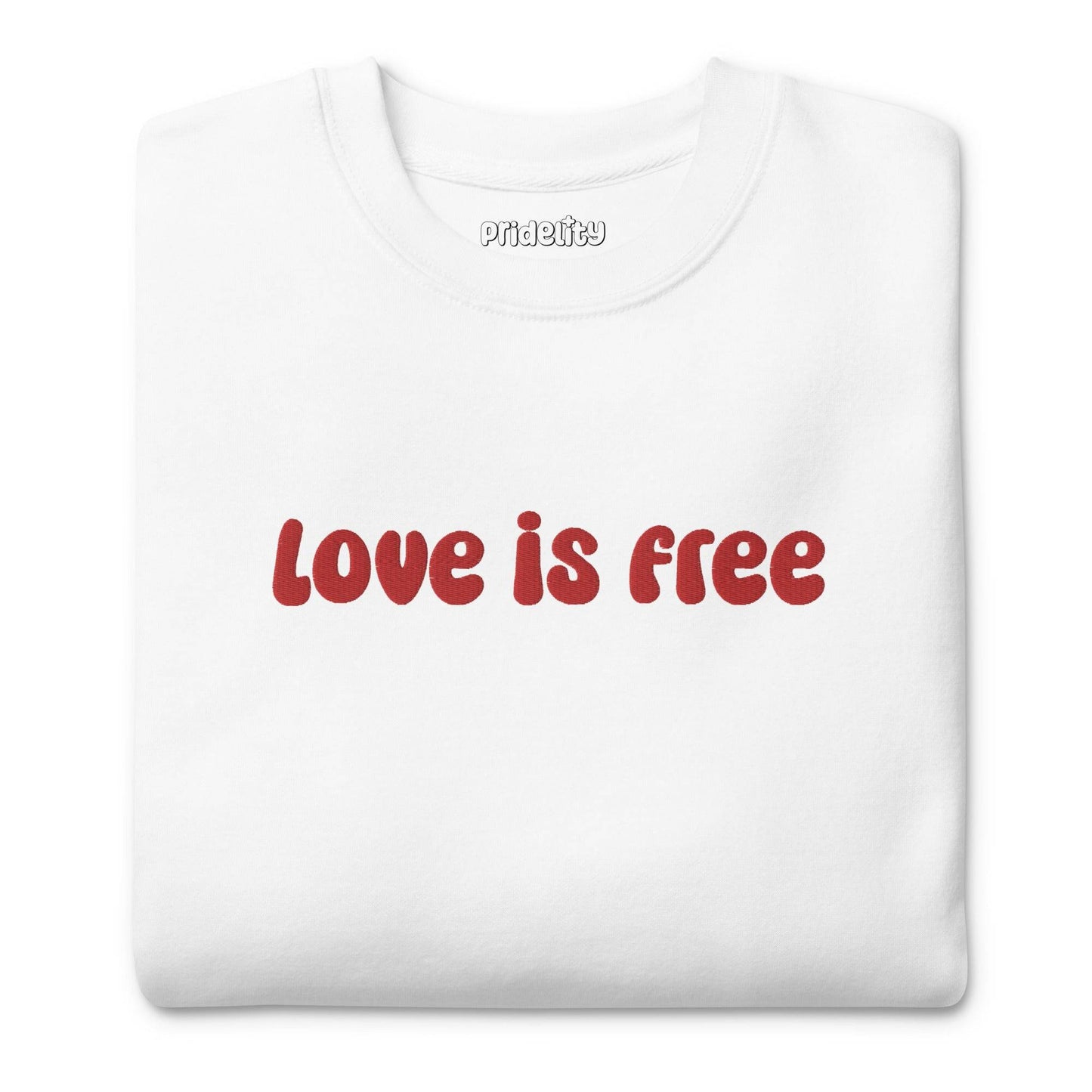 The Love Is Free Sweatshirt by Pridelity is a white sweatshirt with "love is free" boldly displayed in red letters across the chest, capturing the vibrant and inclusive essence of rainbow clothes.