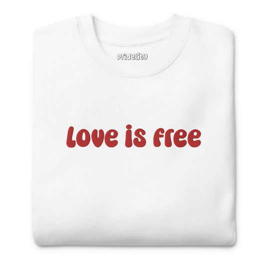 The Love Is Free Sweatshirt by Pridelity is a white sweatshirt with "love is free" boldly displayed in red letters across the chest, capturing the vibrant and inclusive essence of rainbow clothes.