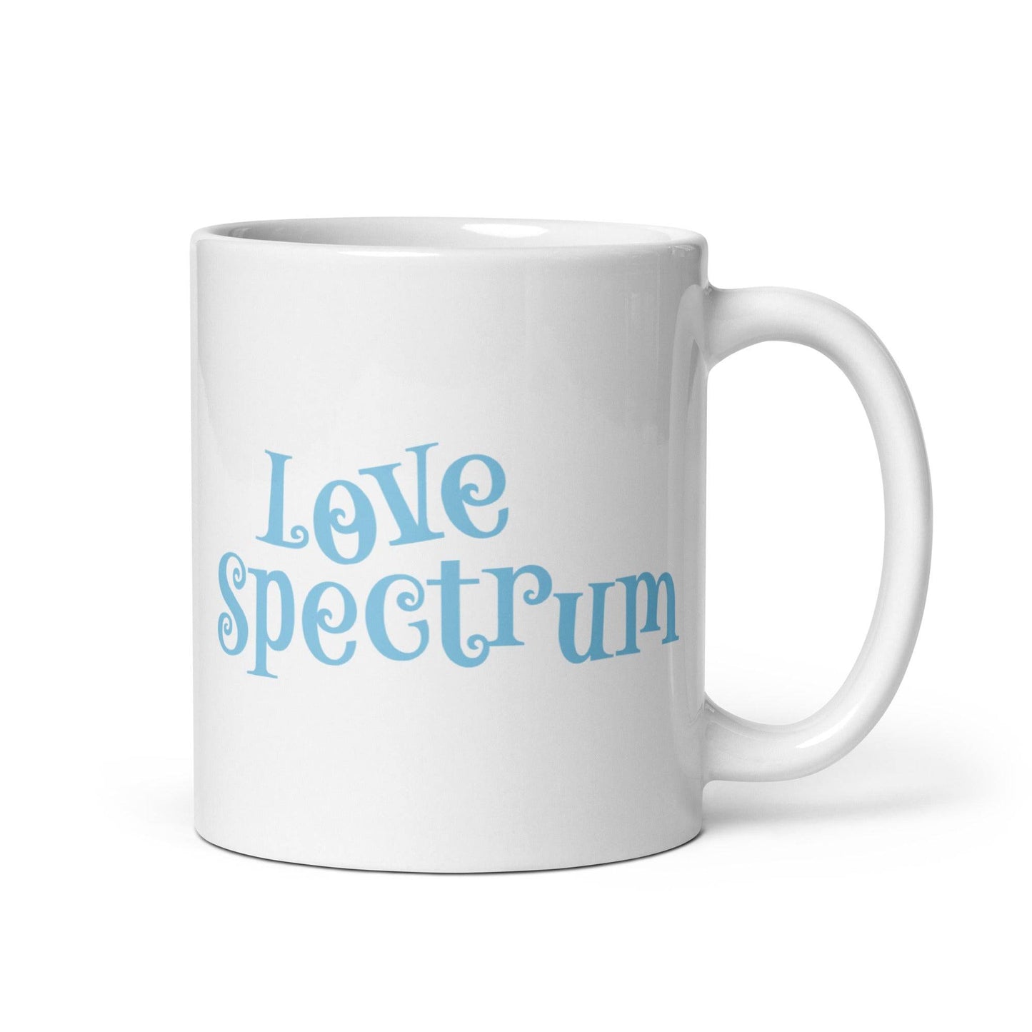 A white coffee mug featuring "Love Spectrum" in light blue, playful letters on one side is part of Pridelity's pride collection for 2025 and showcases a simple and clean design.