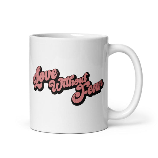 The Love Without Fear Mug by Pridelity is a white mug from the Pride Collections 2025, showcasing "Love Without Fear" in bold pink text with a black outline, elegantly written in a vintage-style cursive font.
