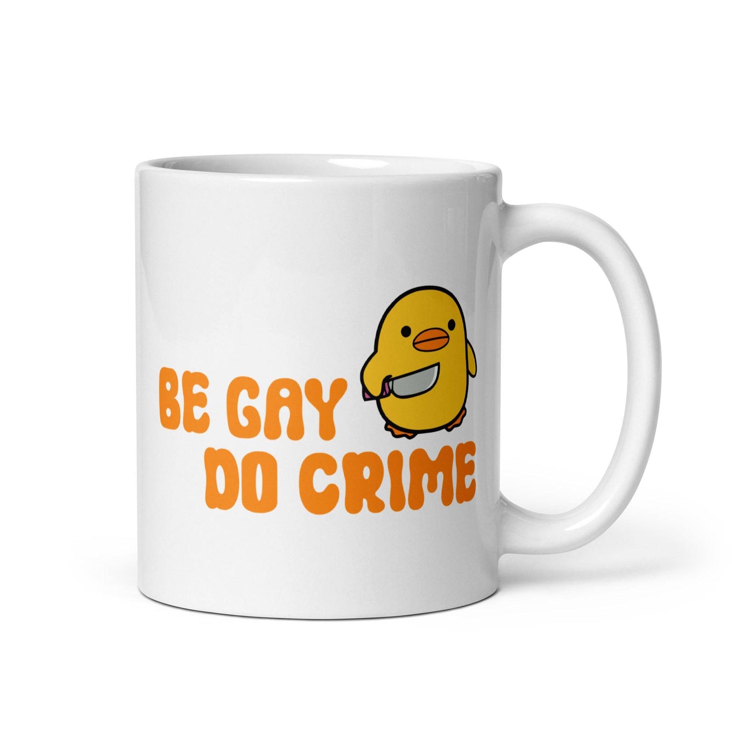 This white mug from Pridelity's Be Gay Do Crime collection showcases a cute yellow duck holding a knife, accompanied by bold orange text reading "Be Gay Do Crime.