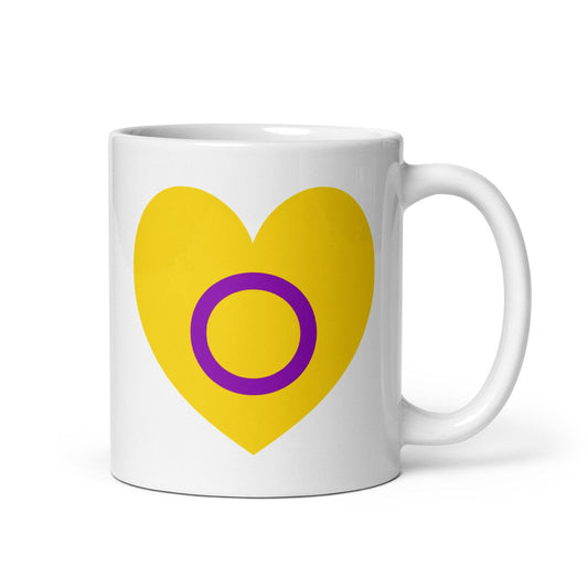 Introducing the Intersex Heart Mug from Pridelity's renowned 2025 pride collection. This white mug features a vibrant yellow heart with a purple circle at its center, and its elegantly placed handle on the right side adds to its charm.