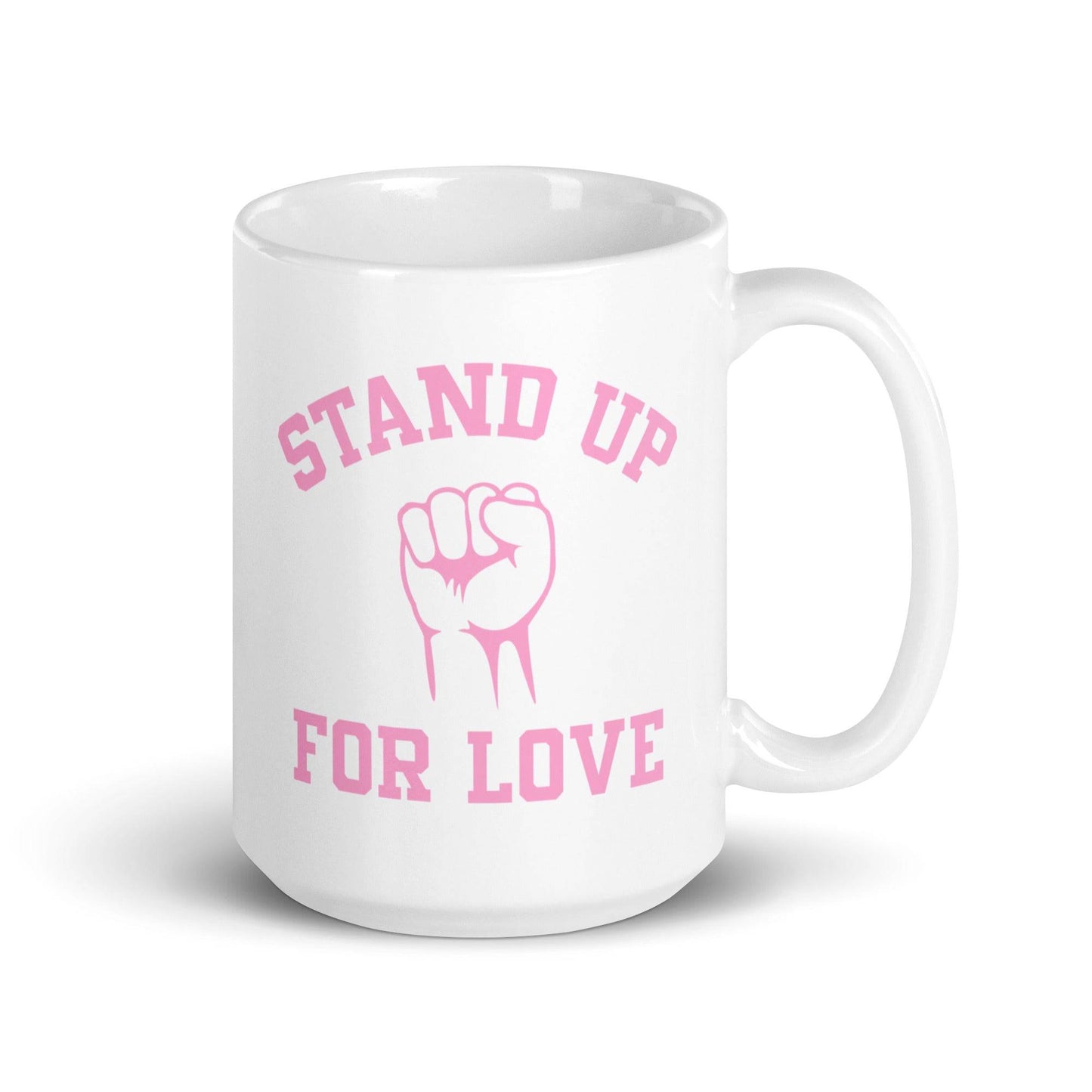 The "Stand Up For Love" mug from Pridelity features pink text on a white background, reading "Stand Up for Love," with an image of a raised fist between the words. As part of the Pride Collections 2025, it symbolizes unity and love.