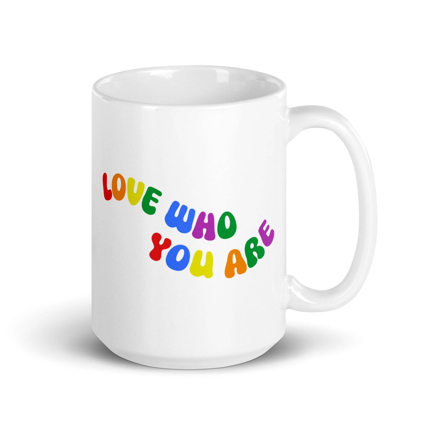 The Love Who You Are Mug by Pridelity is a white mug featuring vibrant letters spelling "LOVE WHO YOU ARE" on its side. It has a smooth handle and a simple background, and is part of the Pride Collections 2025, celebrating uniqueness and self-love.