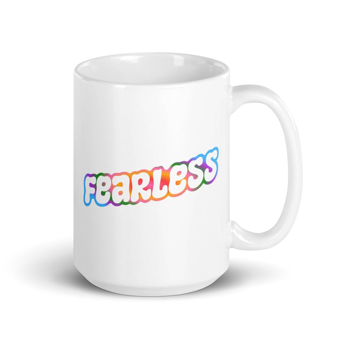 Introducing the Fearless Mug by Pridelity: a striking white mug featuring the word "fearless" in bubble-style letters, accented with a vibrant gradient of pink, orange, yellow, and blue. Part of the standout best pride collections for 2025, this mug offers a simple yet impactful design.