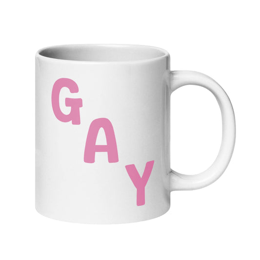 This mug by Pridelity, from the best pride collections of 2025, showcases the word "GAY" in bold pink capital letters, arranged diagonally on a white surface.