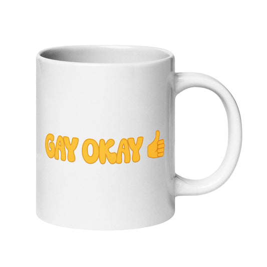 The "Gay Okay Mug" by Pridelity features bold yellow letters spelling "GAY OKAY" on a white coffee mug, complete with a thumbs-up emoji—it's a standout piece from the best pride collections of 2025.