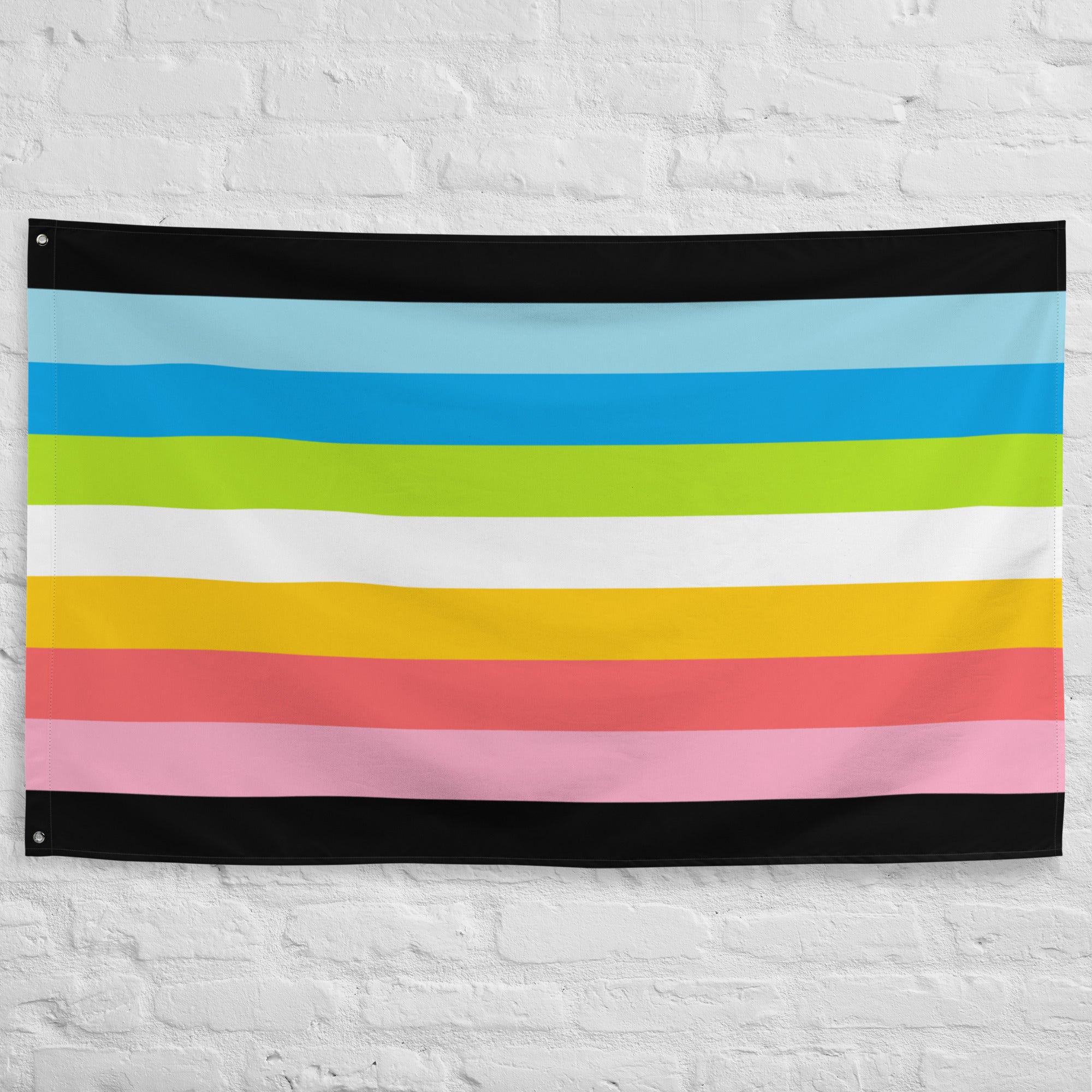 The Queer Pride Flag by Pridelity showcases vibrant horizontal stripes in blue, green, yellow, pink, and white, bordered by sleek black lines. This lively display from Rainbow Shop graces a white brick wall.