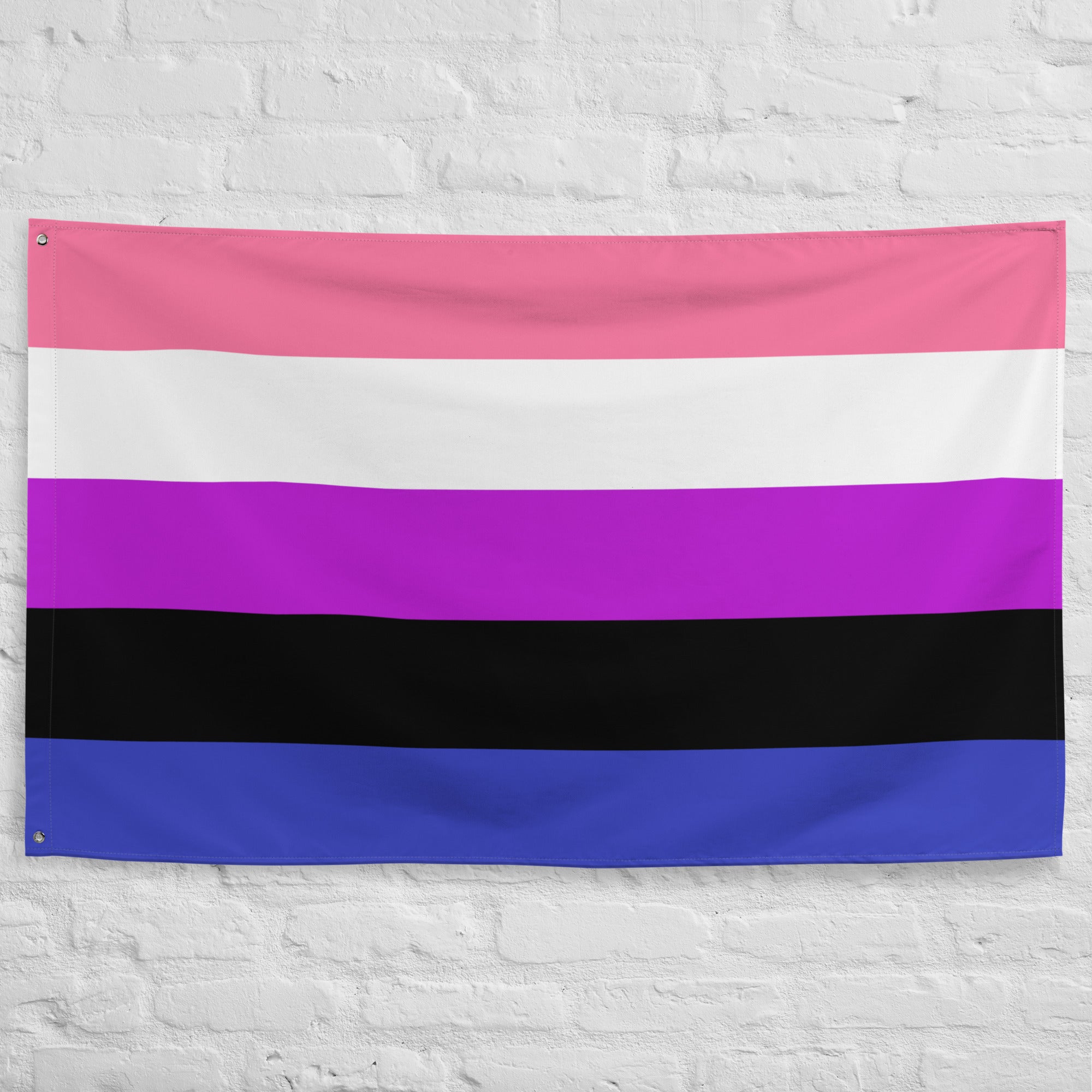 The image showcases a lively scene of the Pridelity Genderfluid Pride Flag displayed on a white brick wall, resembling a colorful shop exhibit. The flag has five horizontal stripes in pink, white, purple, black, and blue.