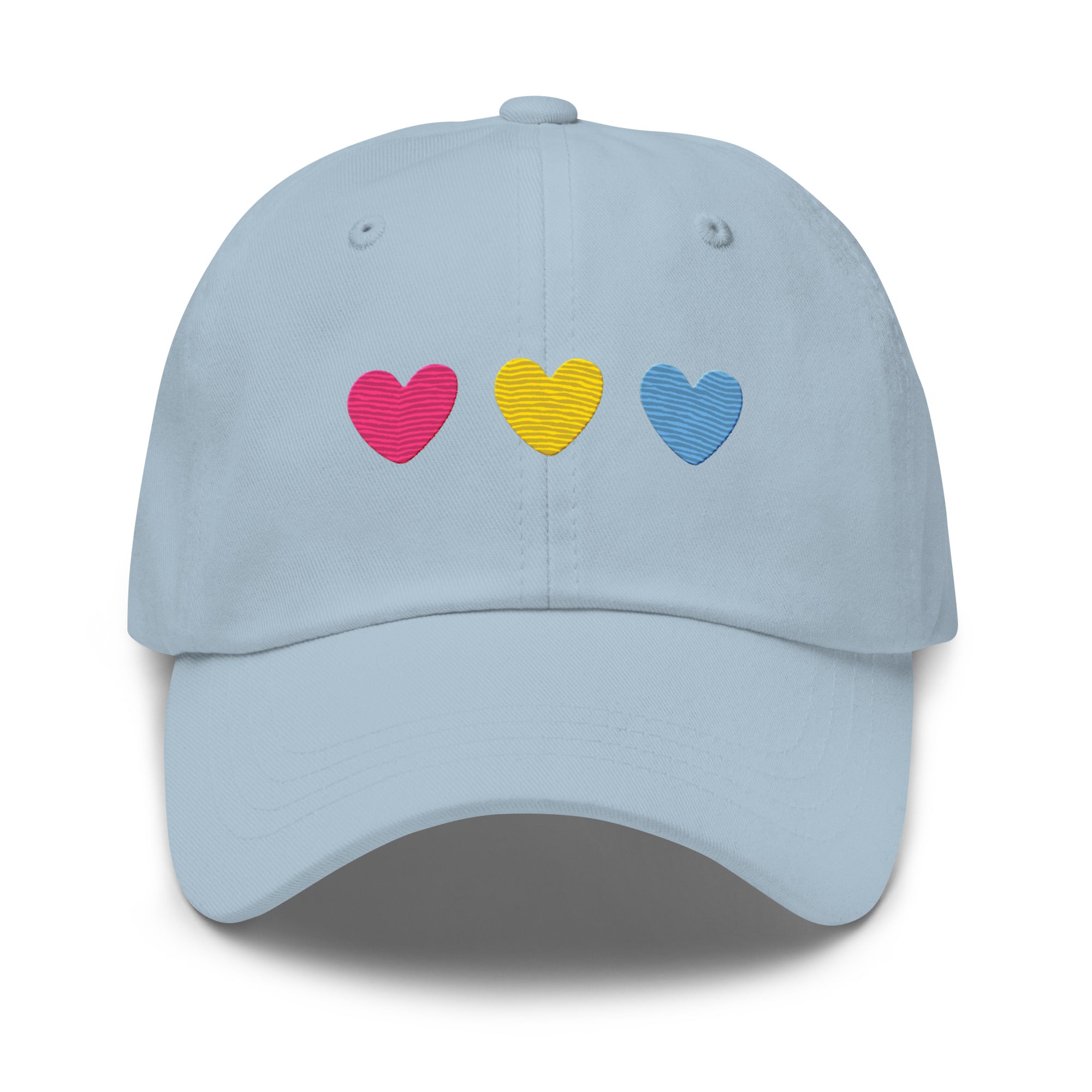 The Pan Hearts Cap by Pridelity, in a light blue hue, brings a playful touch to pride outfits with its three vibrantly embroidered hearts in pink, yellow, and blue.